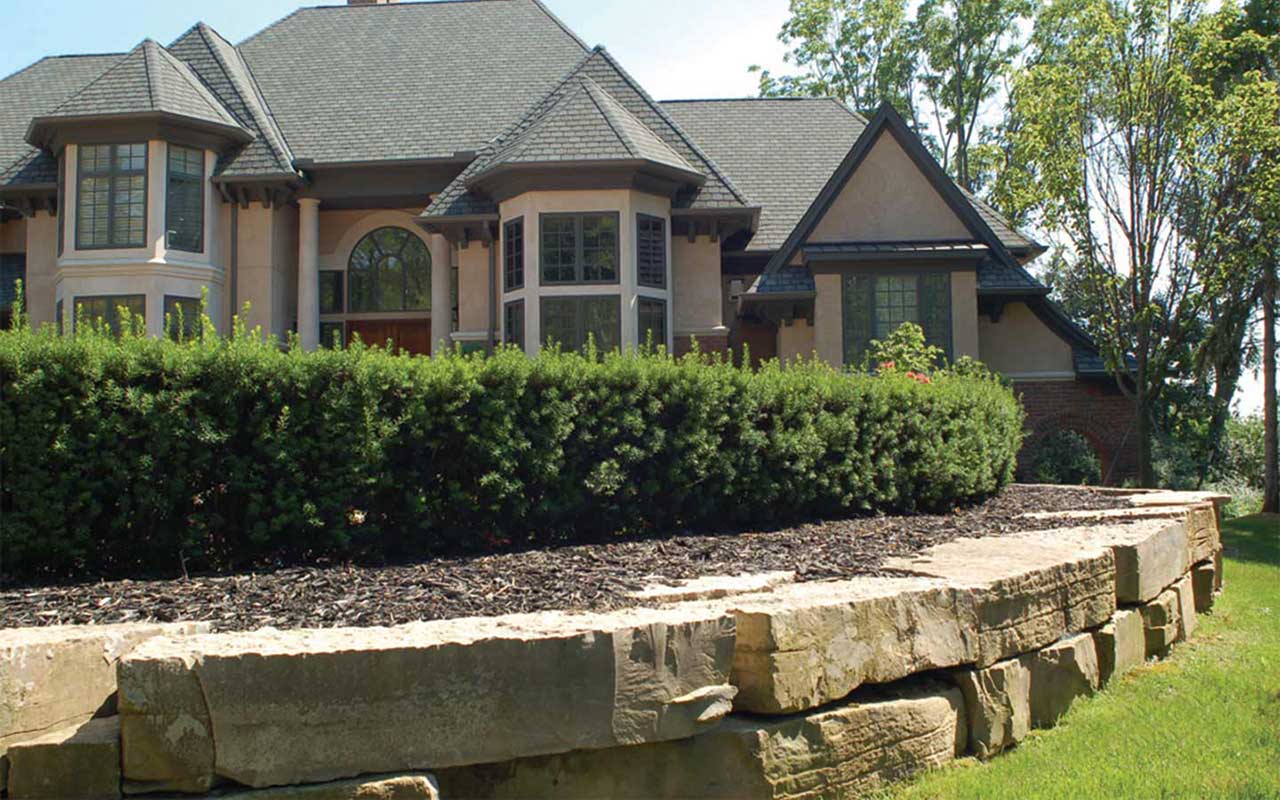 a large house with a stone wall in front of it