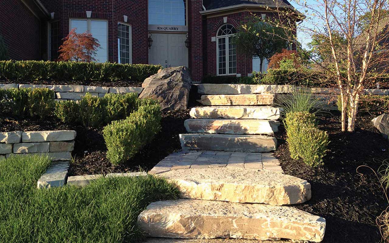a stone walkway leading up to a brick house