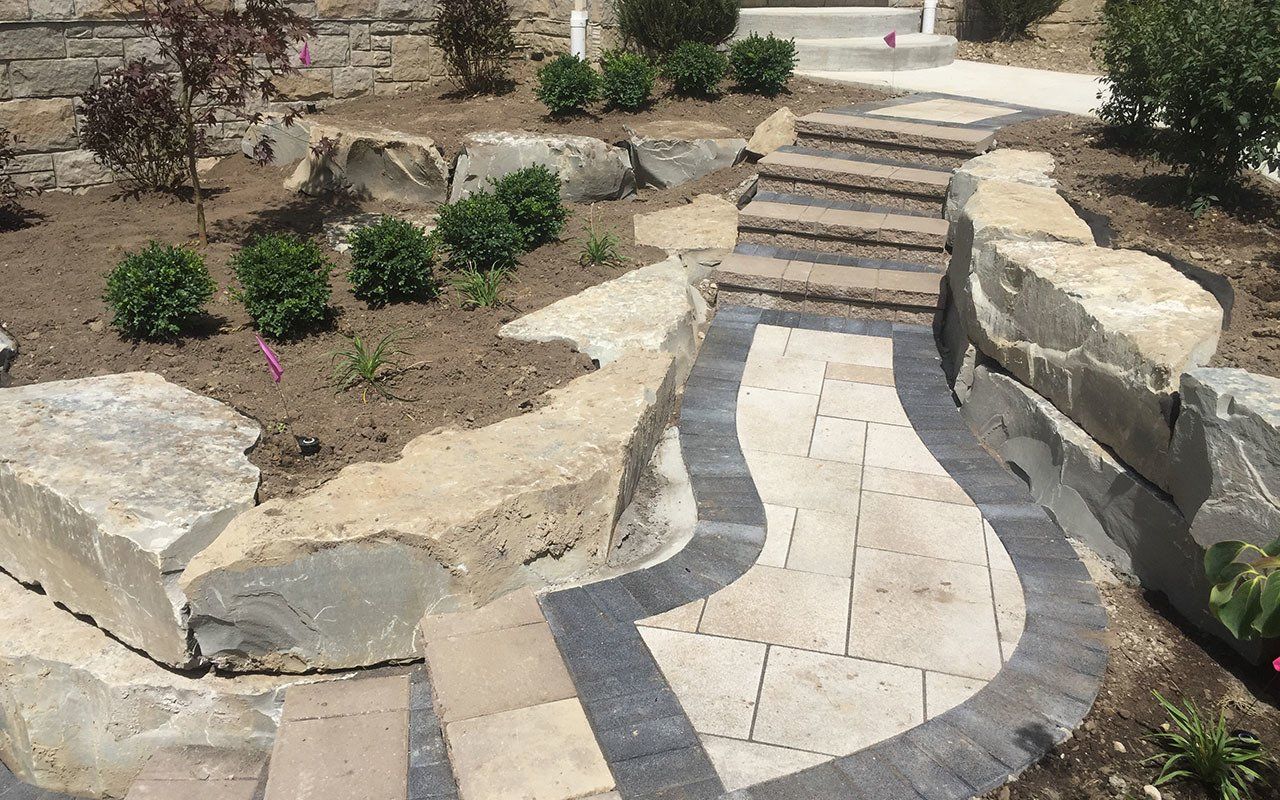 a stone walkway with stairs leading up to a house .