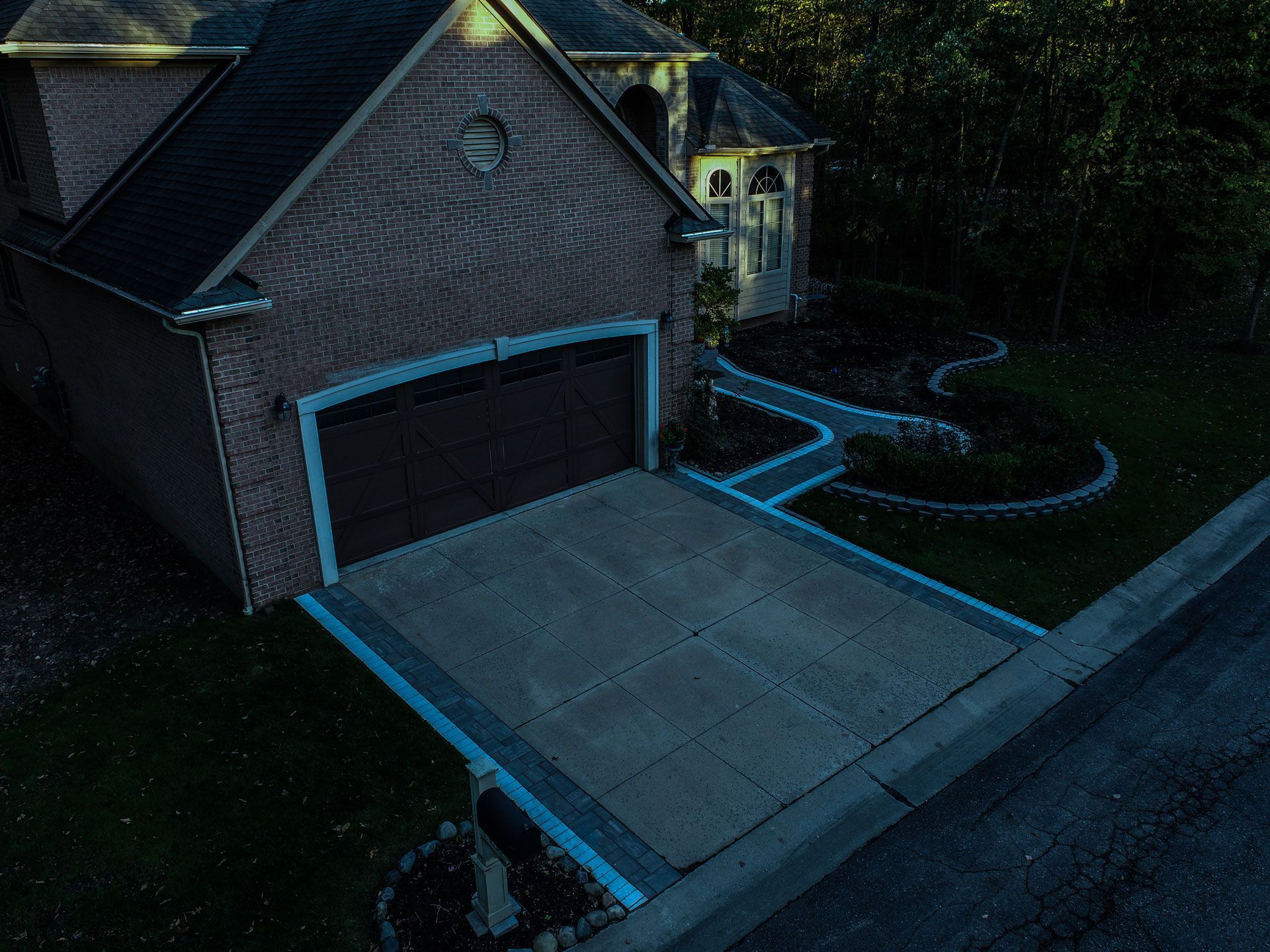 an aerial view of a house with a garage and driveway painted blue .