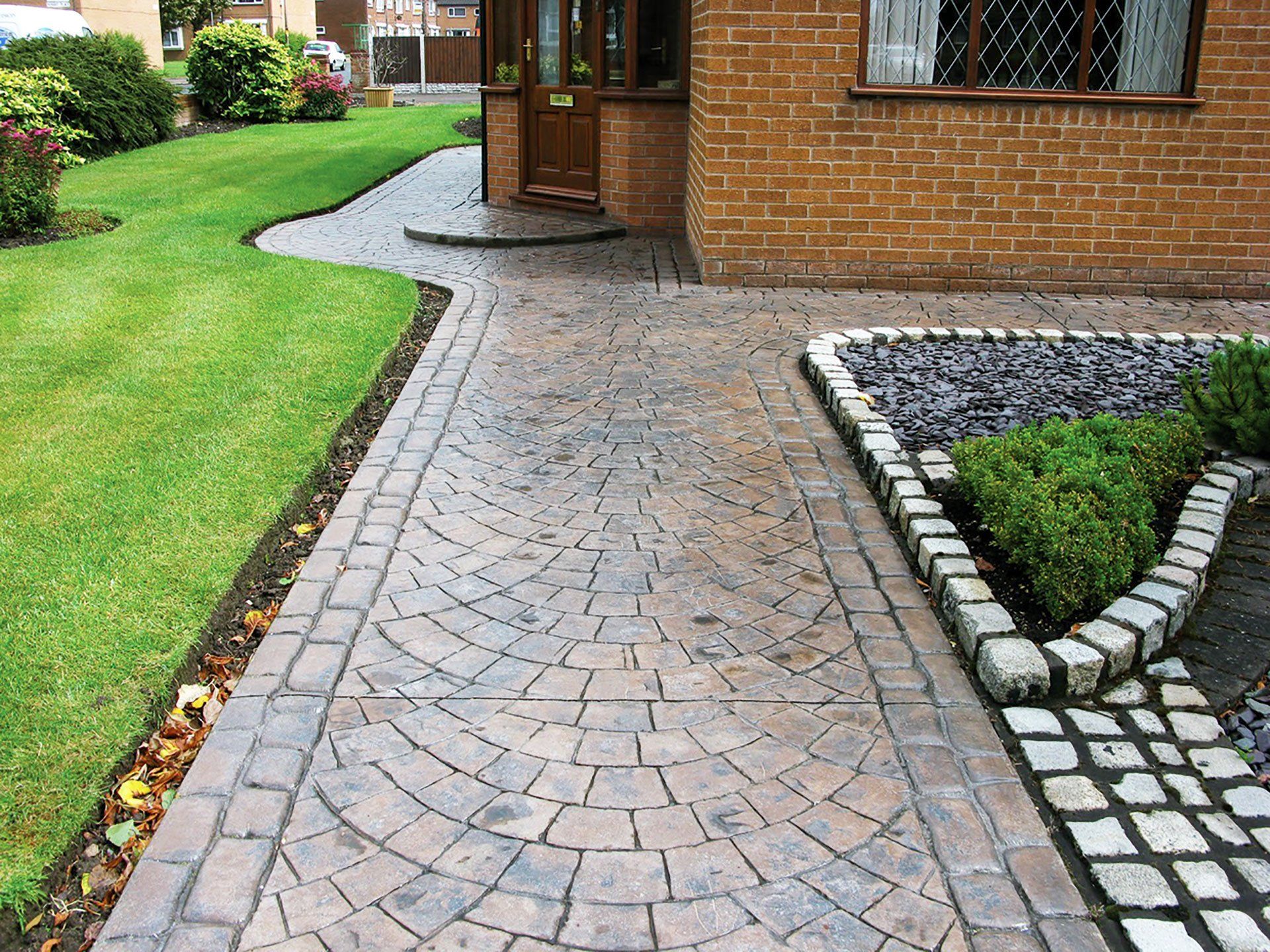 a brick walkway leading to a brick house