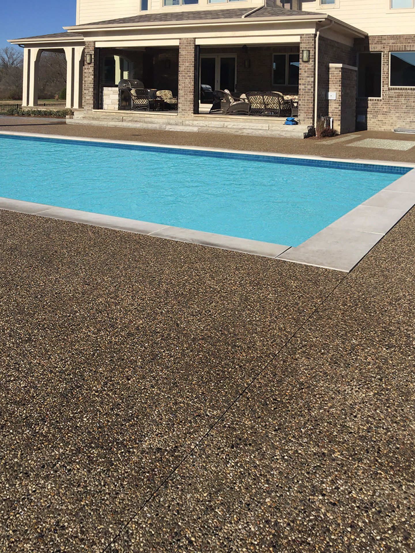 a large swimming pool is in front of a large house .