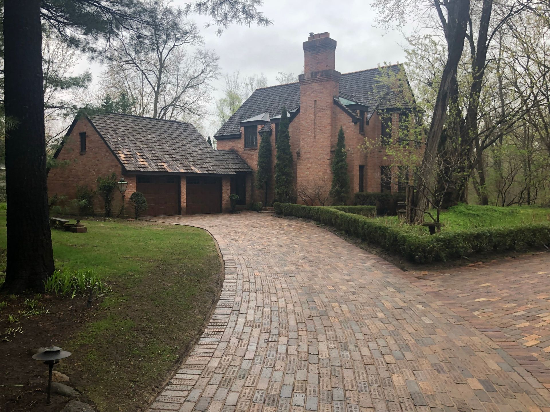 A large brick house with a brick driveway leading to it