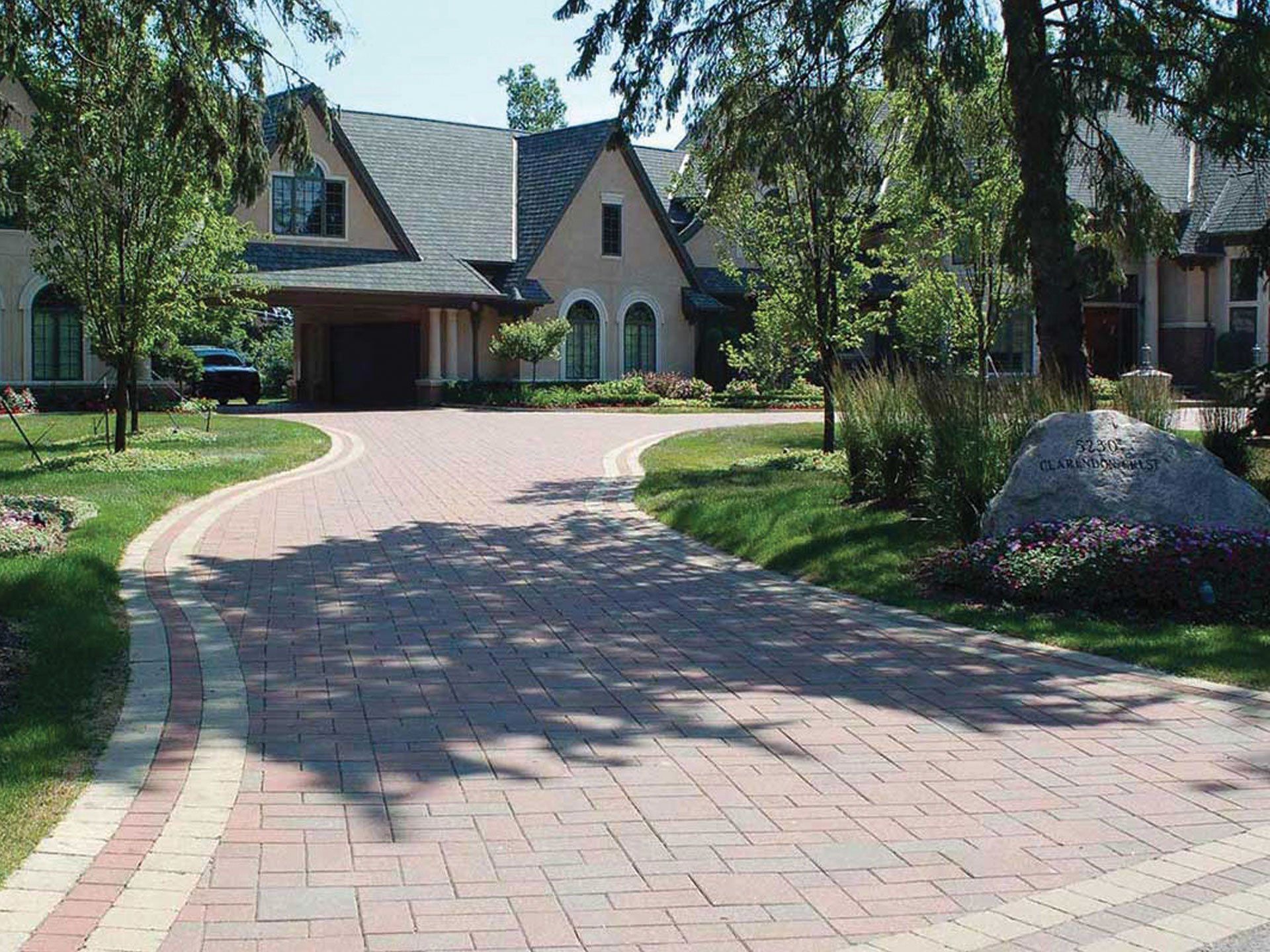 a brick driveway leading to a large house