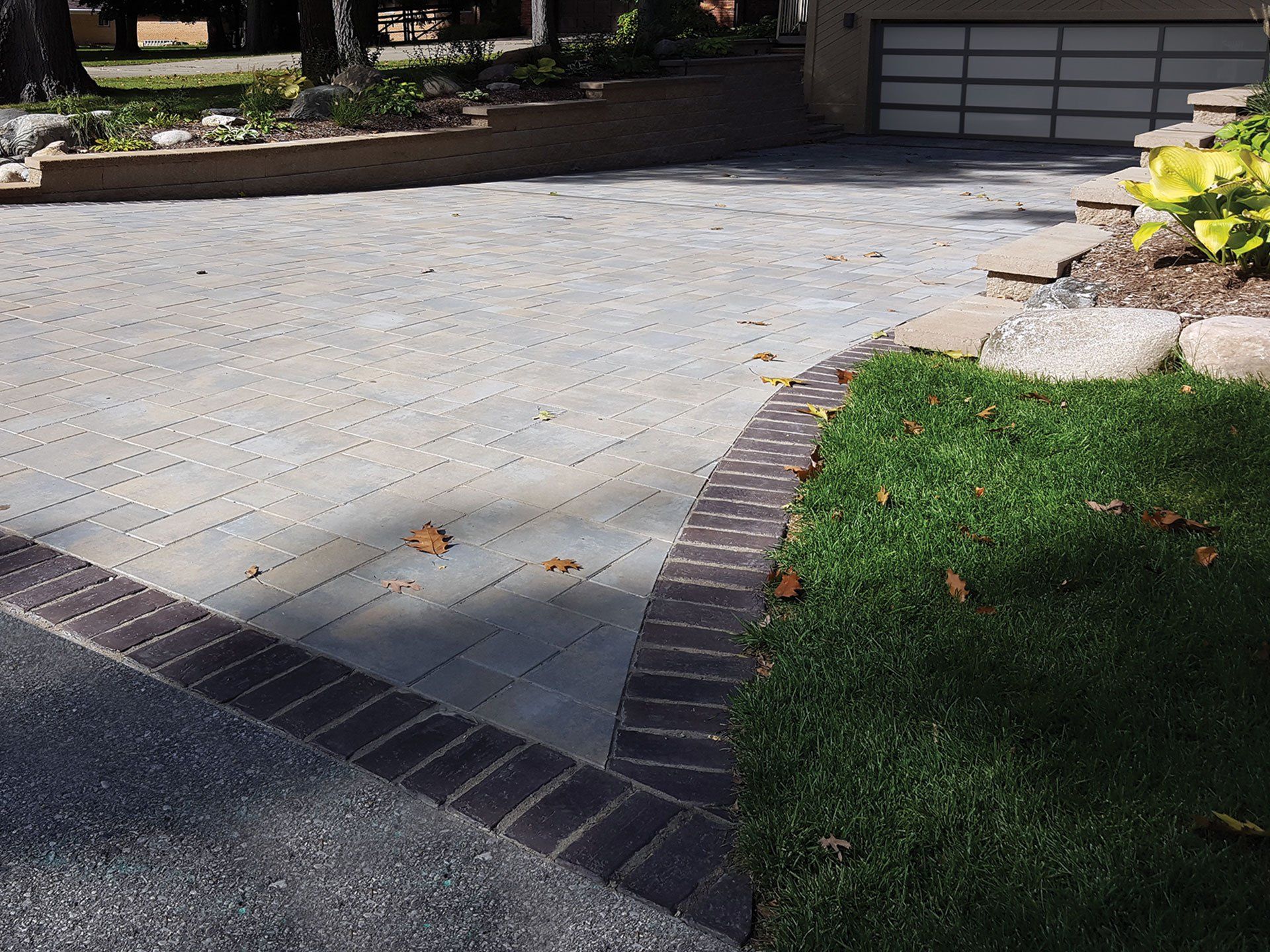 a driveway in front of a house with a brick border
