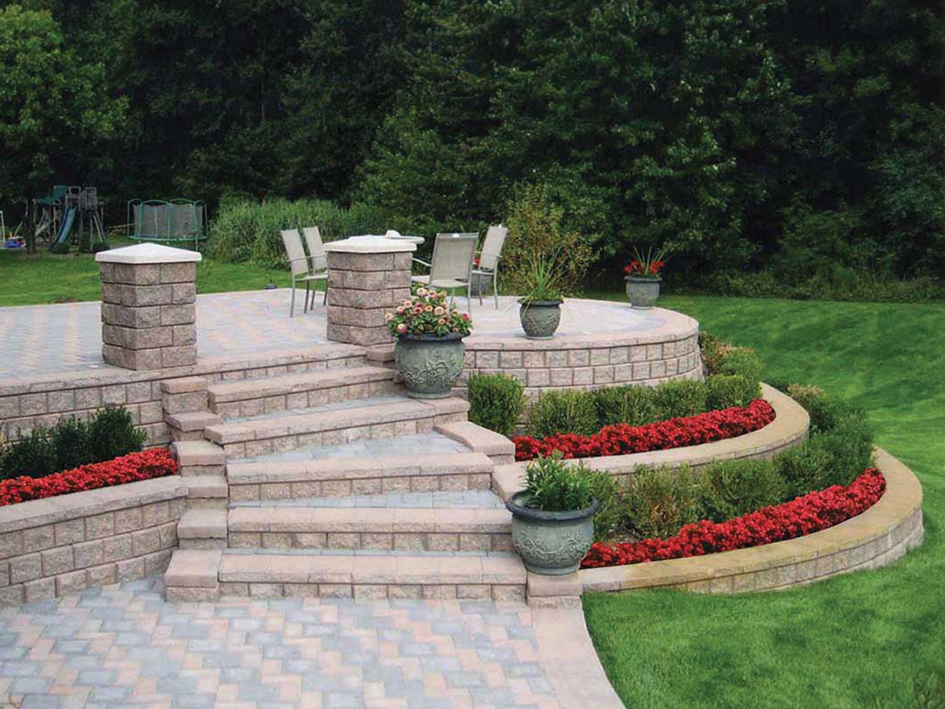 a patio with stairs leading up to a table and chairs