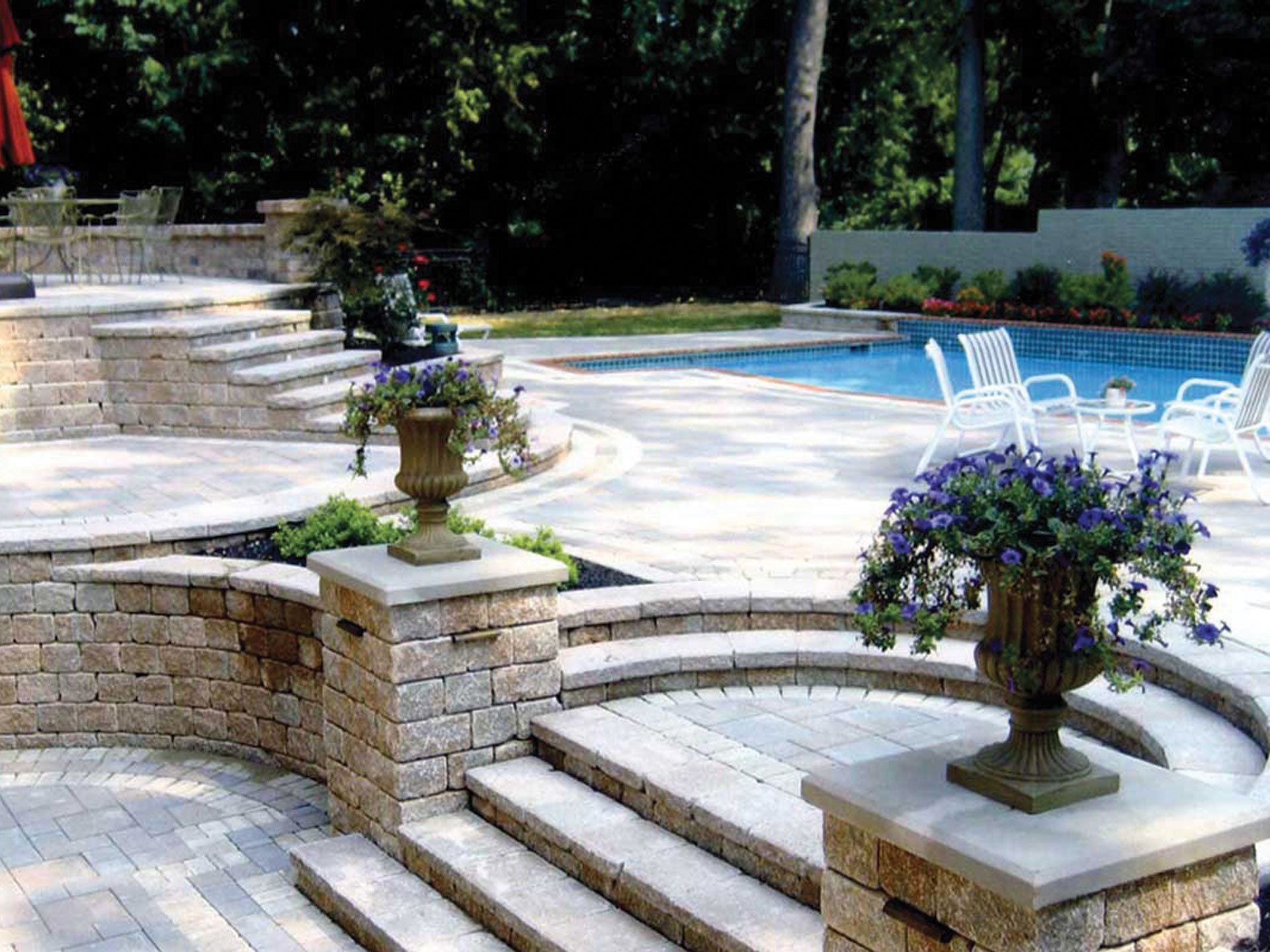 a patio with stairs leading up to a swimming pool
