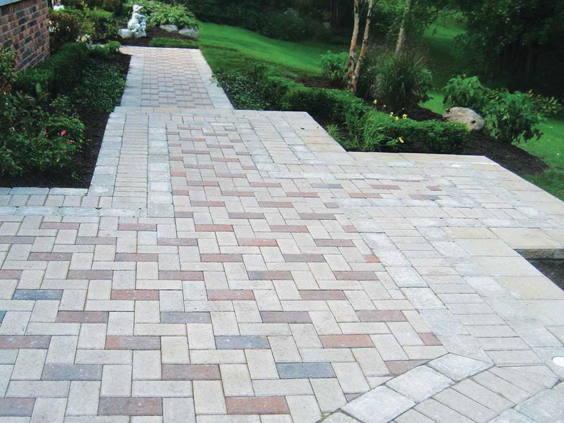 A brick walkway leading to a lush green field