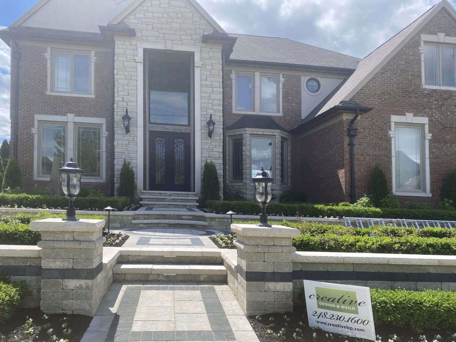 a large brick house with a sign in front of it