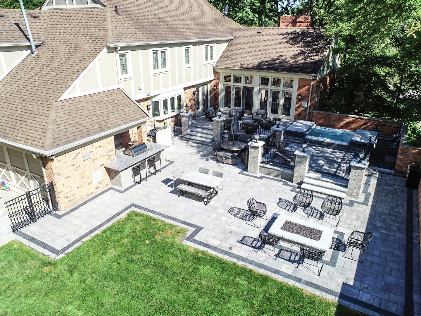 An aerial view of a large backyard with a patio and a fire pit.