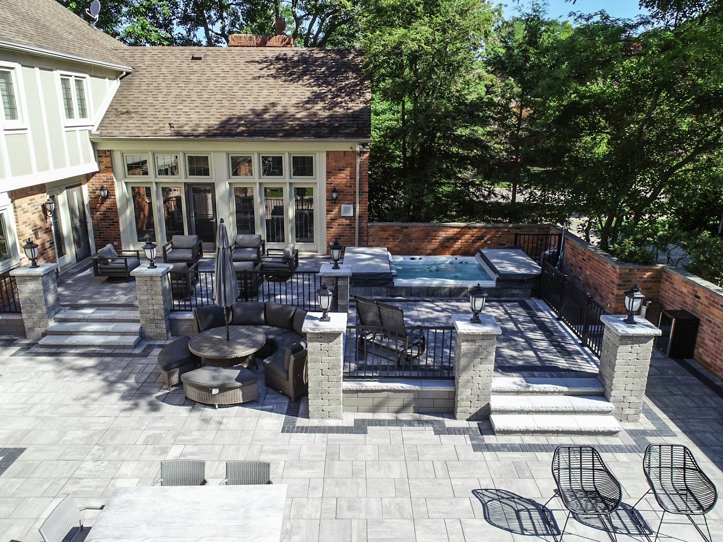 An aerial view of a large patio with tables and chairs and a hot tub.