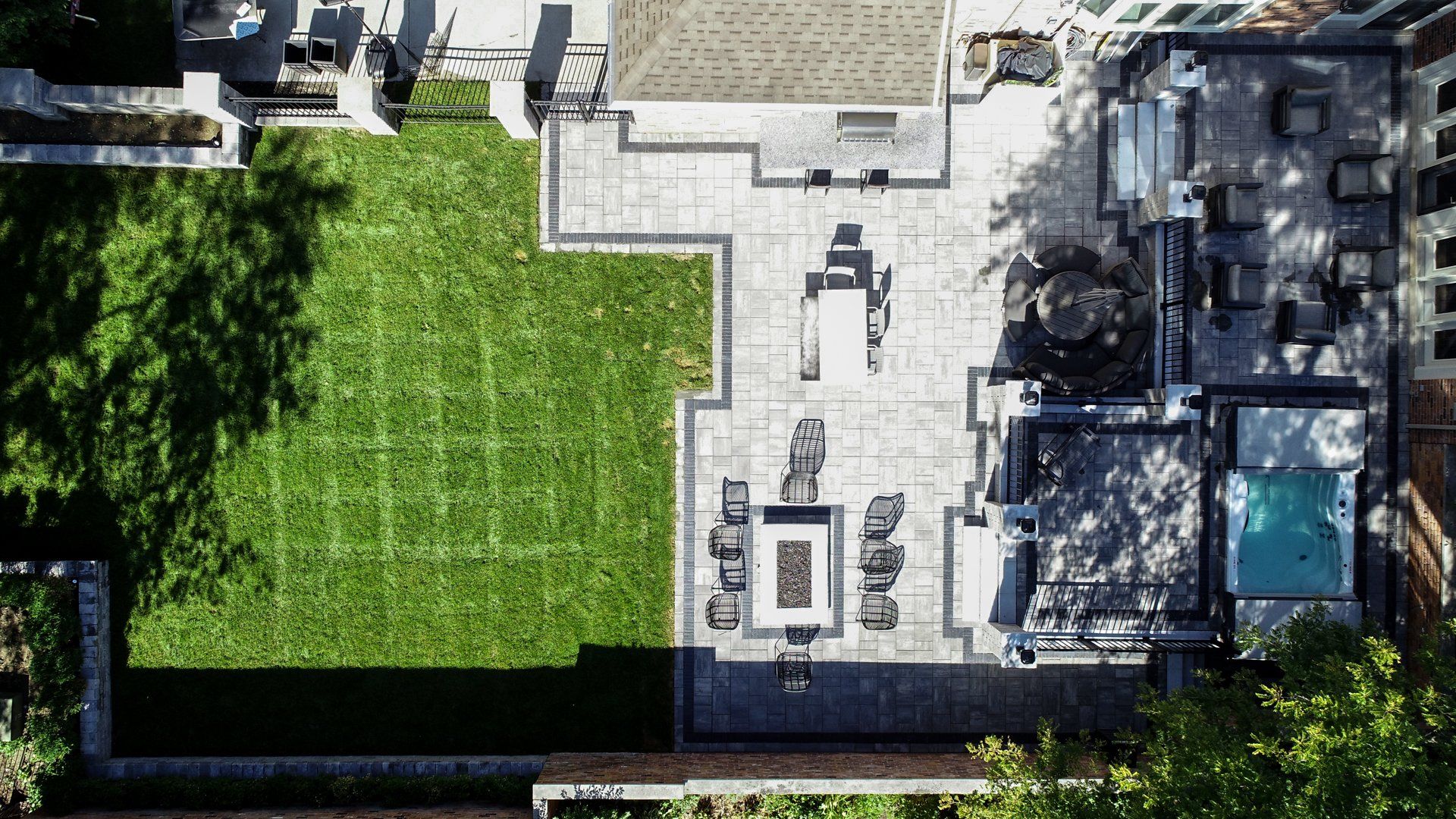 An aerial view of a large house with a large lawn and a pool.