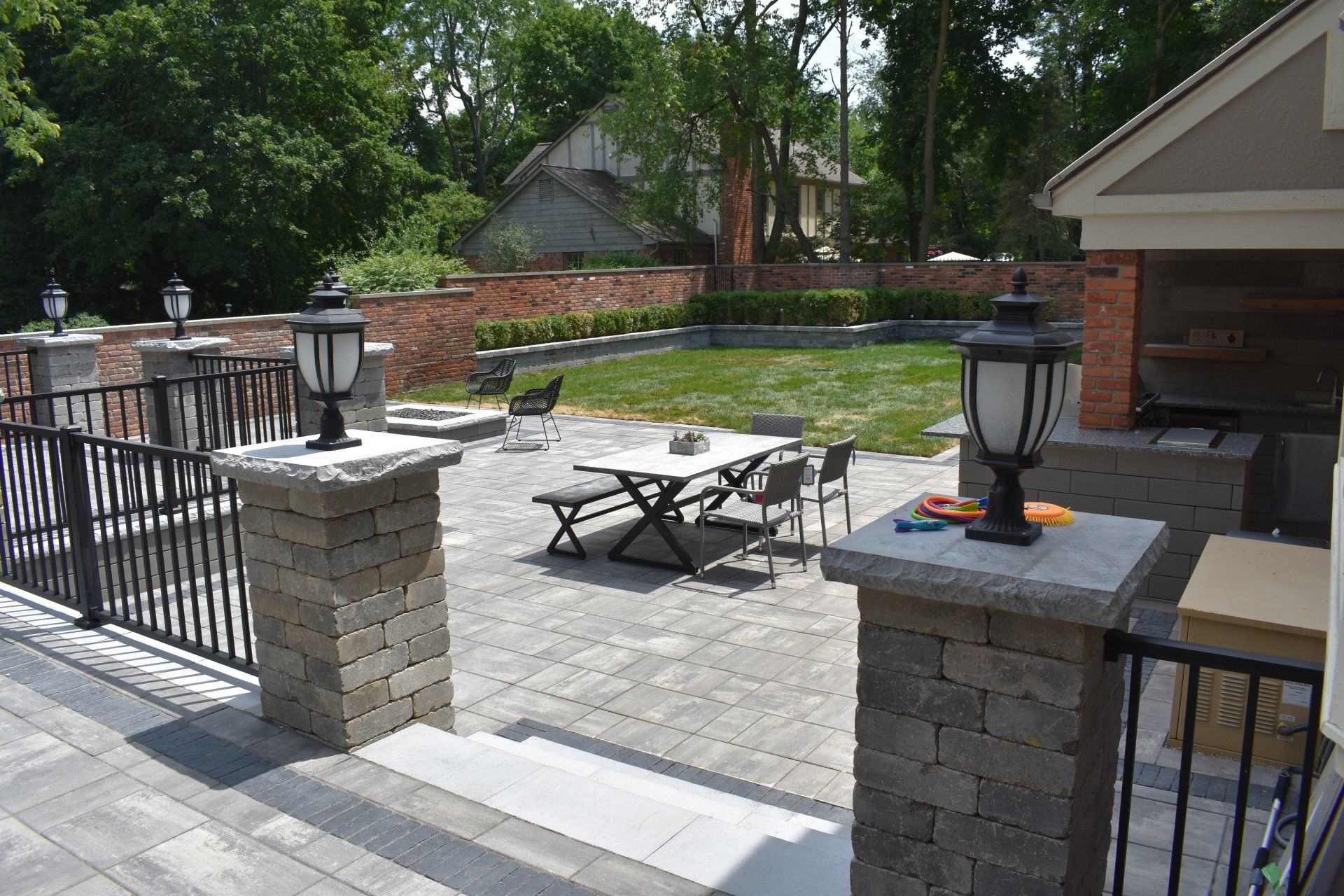 A patio with a table and chairs and a grill