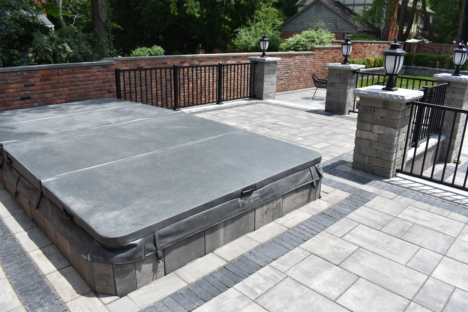 A hot tub cover is sitting on top of a brick patio.