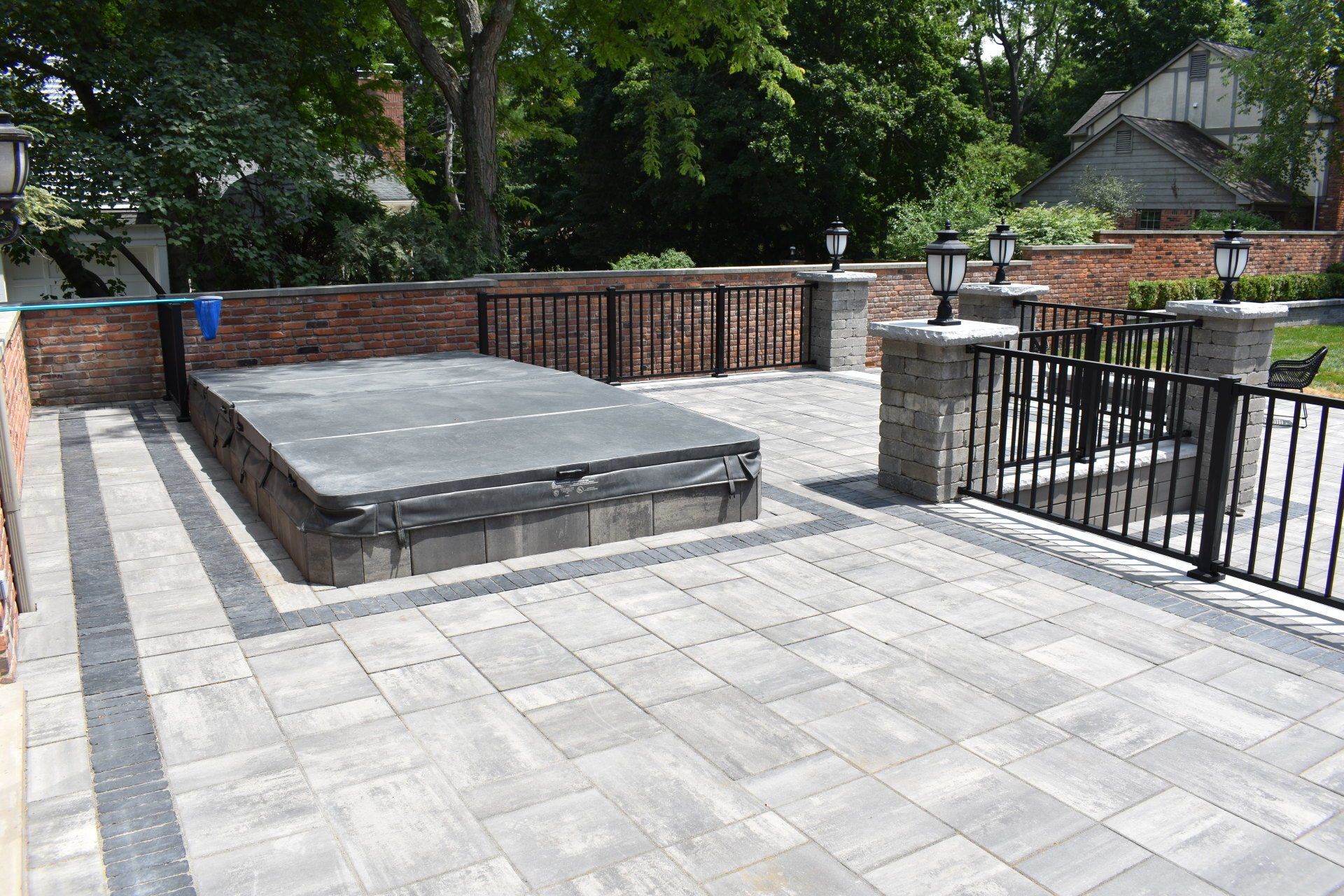 A patio with a hot tub in the middle of it.