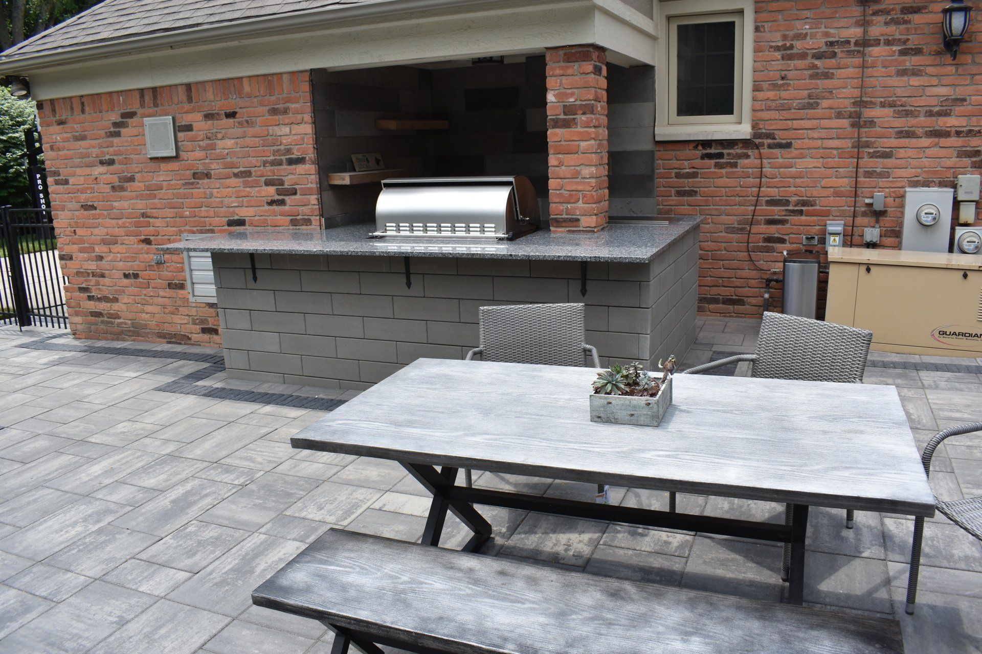 There is a table and benches in front of a brick building.