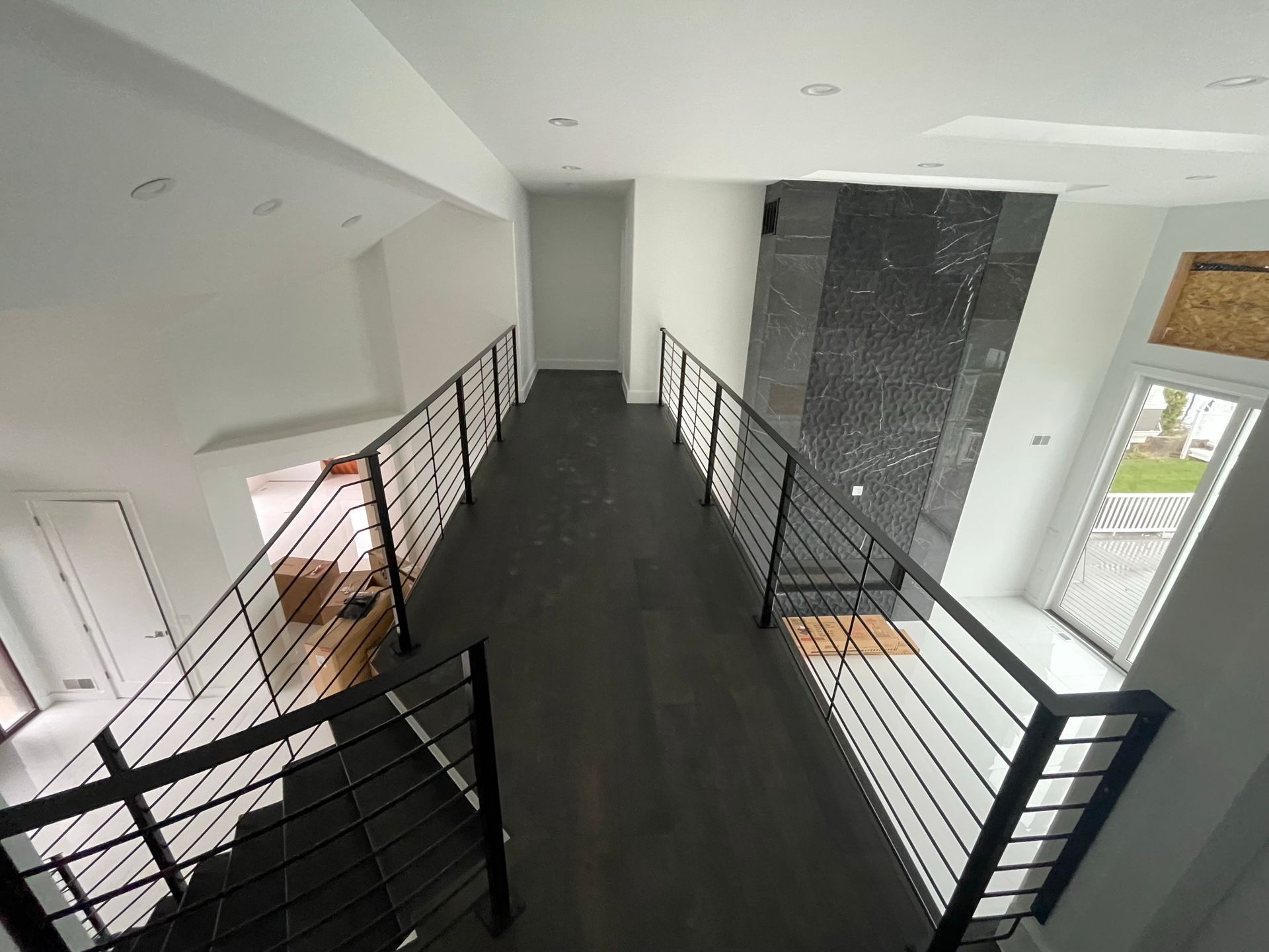 An aerial view of a hallway with stairs and a railing.