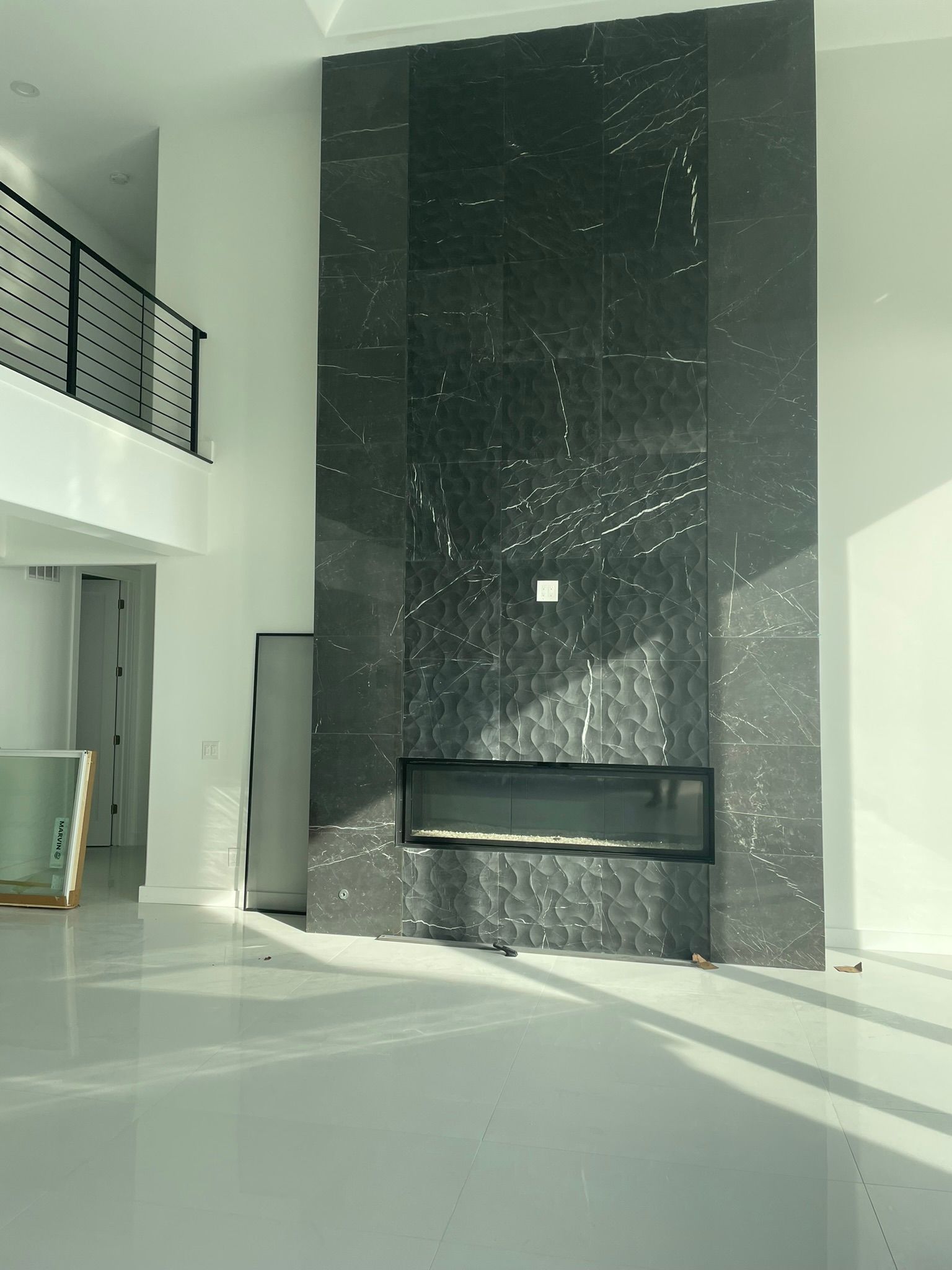 A living room with a fireplace and a balcony