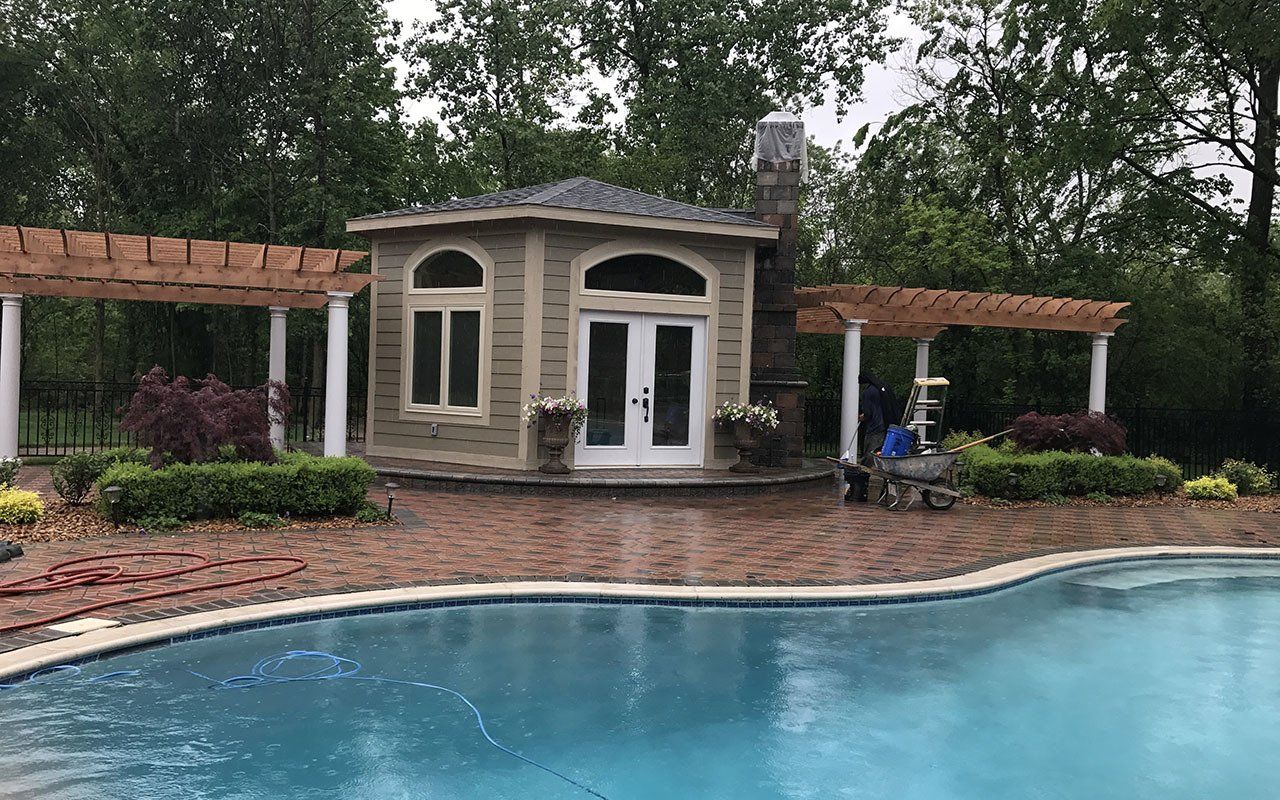 a large swimming pool with a house in the background .