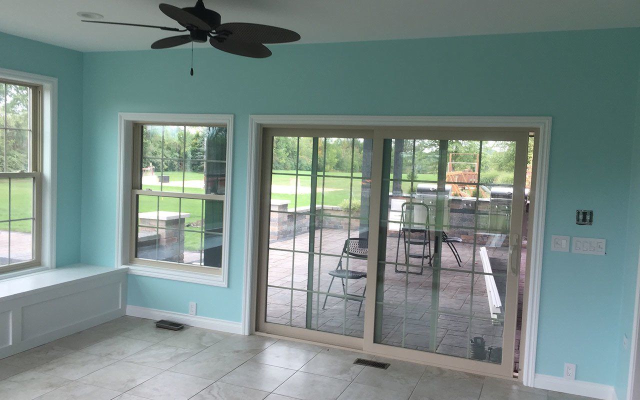 an empty room with a ceiling fan and sliding glass doors .