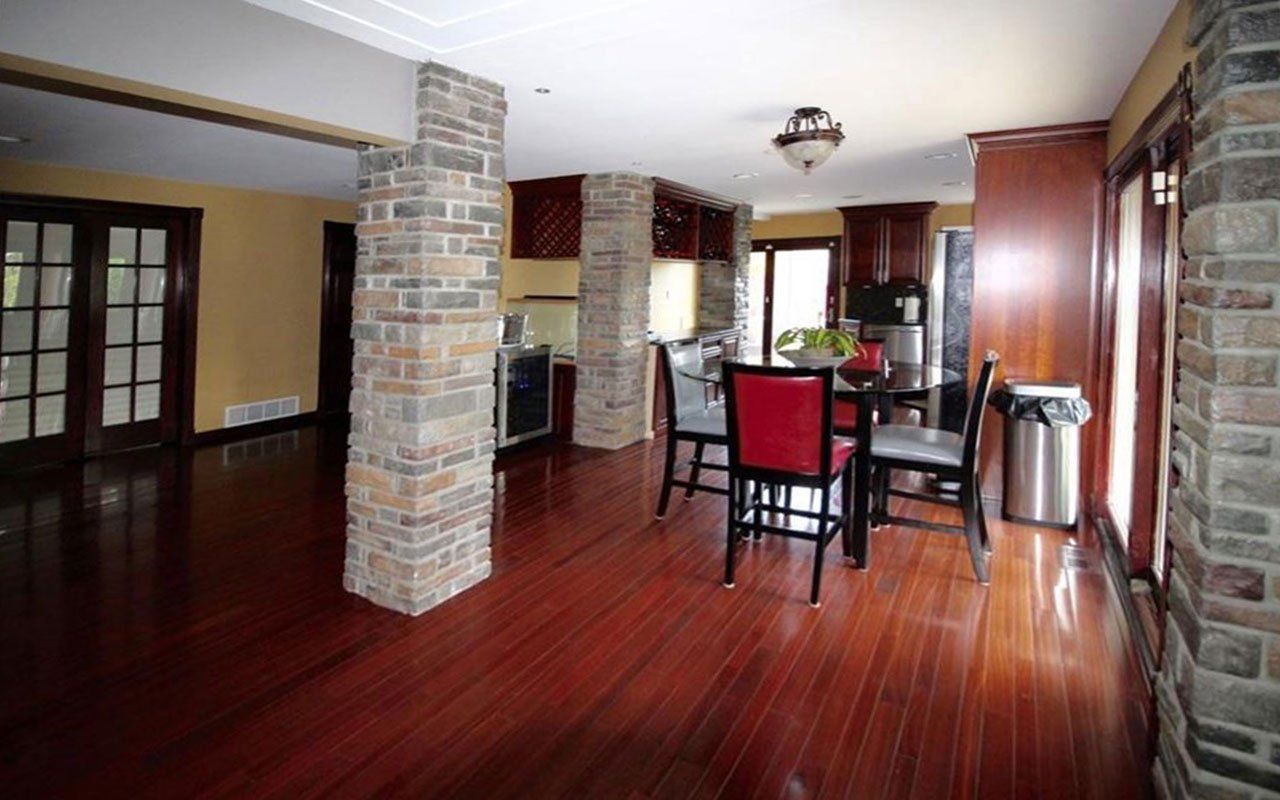 A kitchen with a table and chairs and a trash can