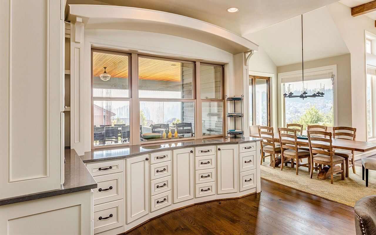 A kitchen with curved cabinets and a large window.