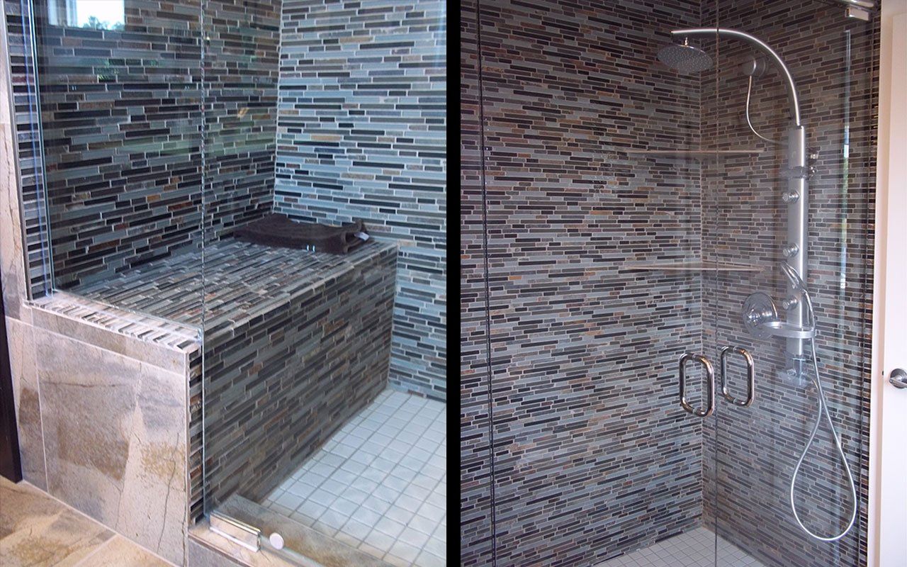 A bathroom with a walk in shower and a tiled wall.