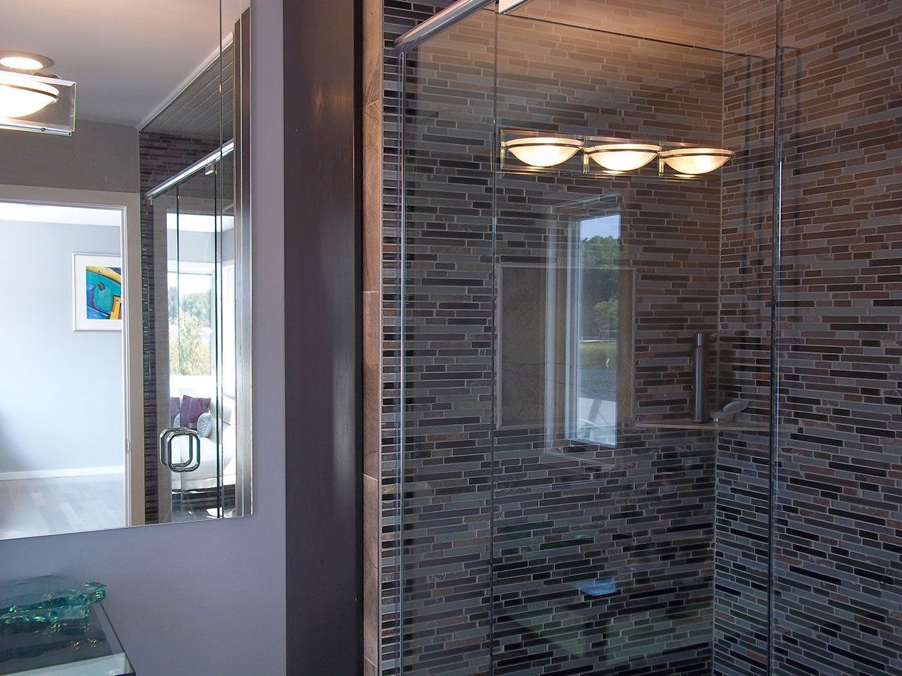 A bathroom with a walk in shower and a mirror.