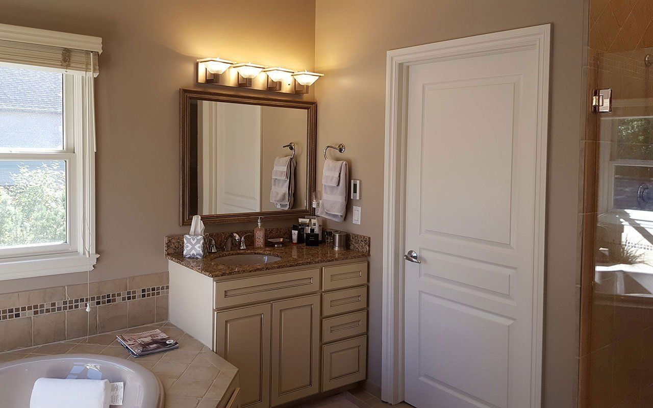 A bathroom with a sink, mirror and tub.