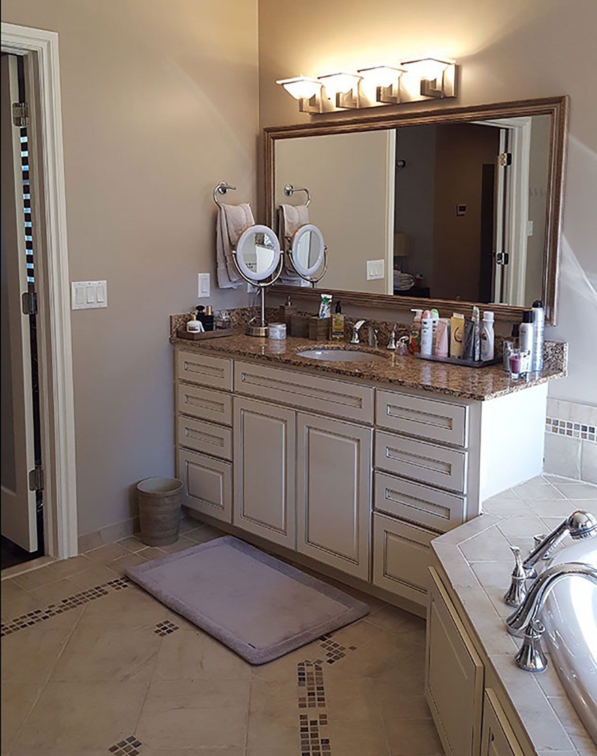A bathroom with a sink, mirror, and bathtub.