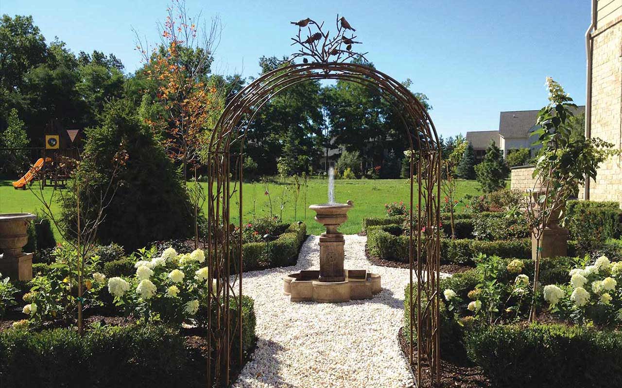 a garden with a fountain in the middle of it