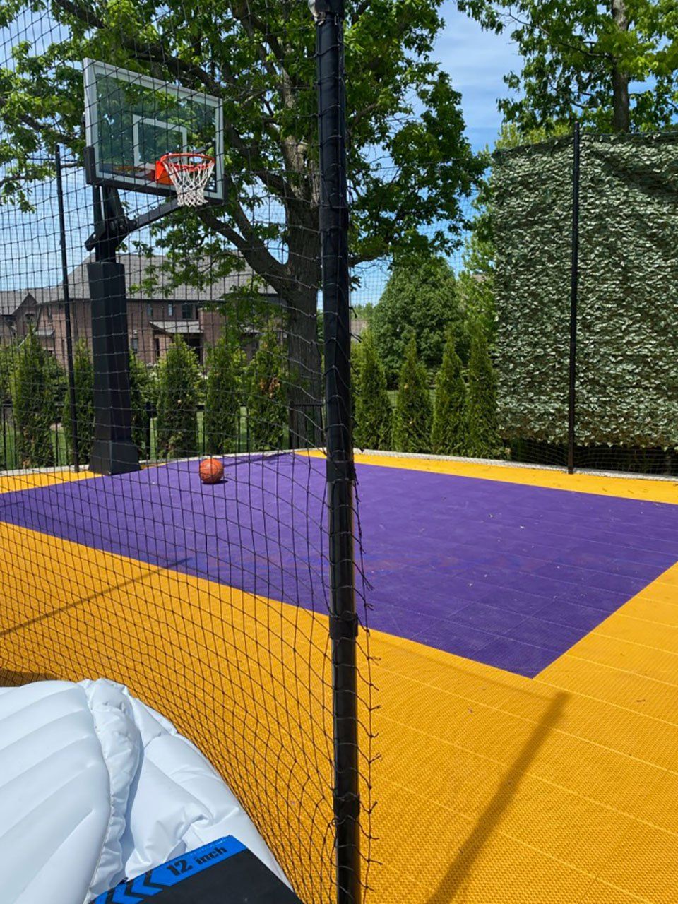 a purple and yellow basketball court with a basketball in the net