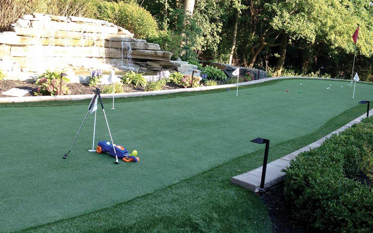 a putting green with a waterfall in the background