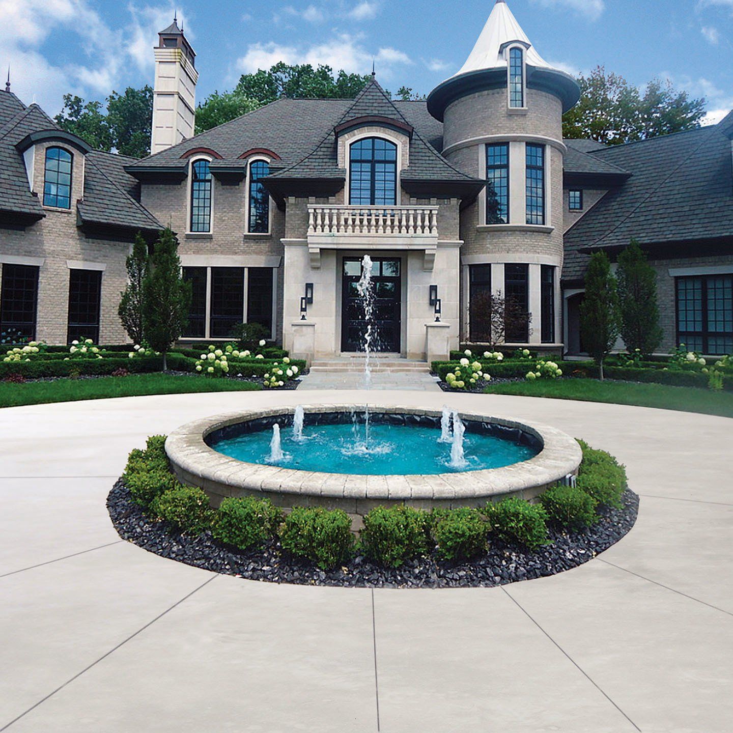 a large house with a fountain in front of it