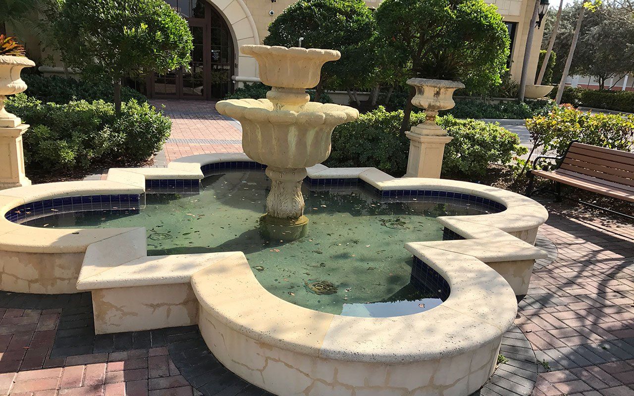 a fountain with a bench in front of it in a park .