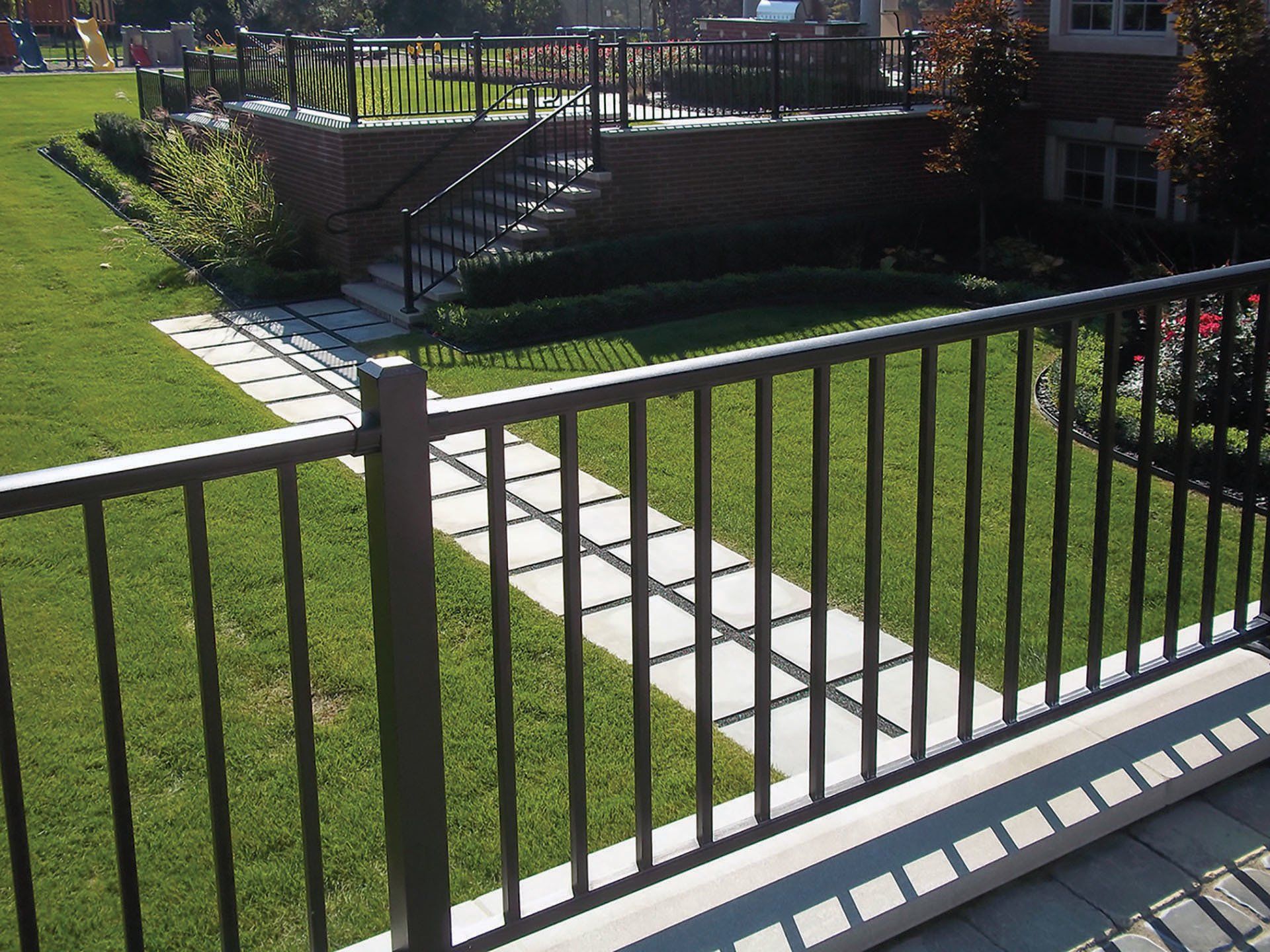 a metal fence surrounds a lush green yard