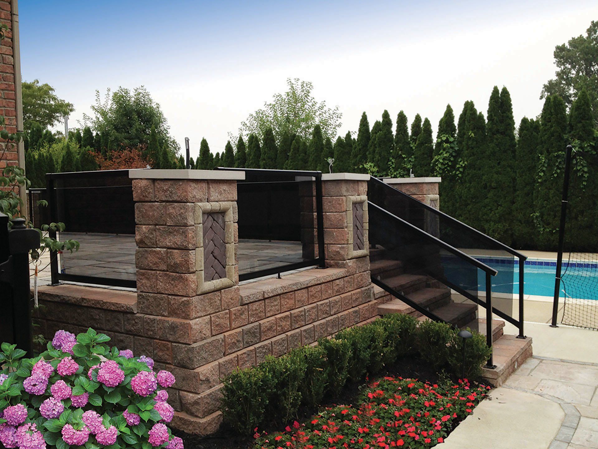 a brick wall with stairs leading up to a swimming pool