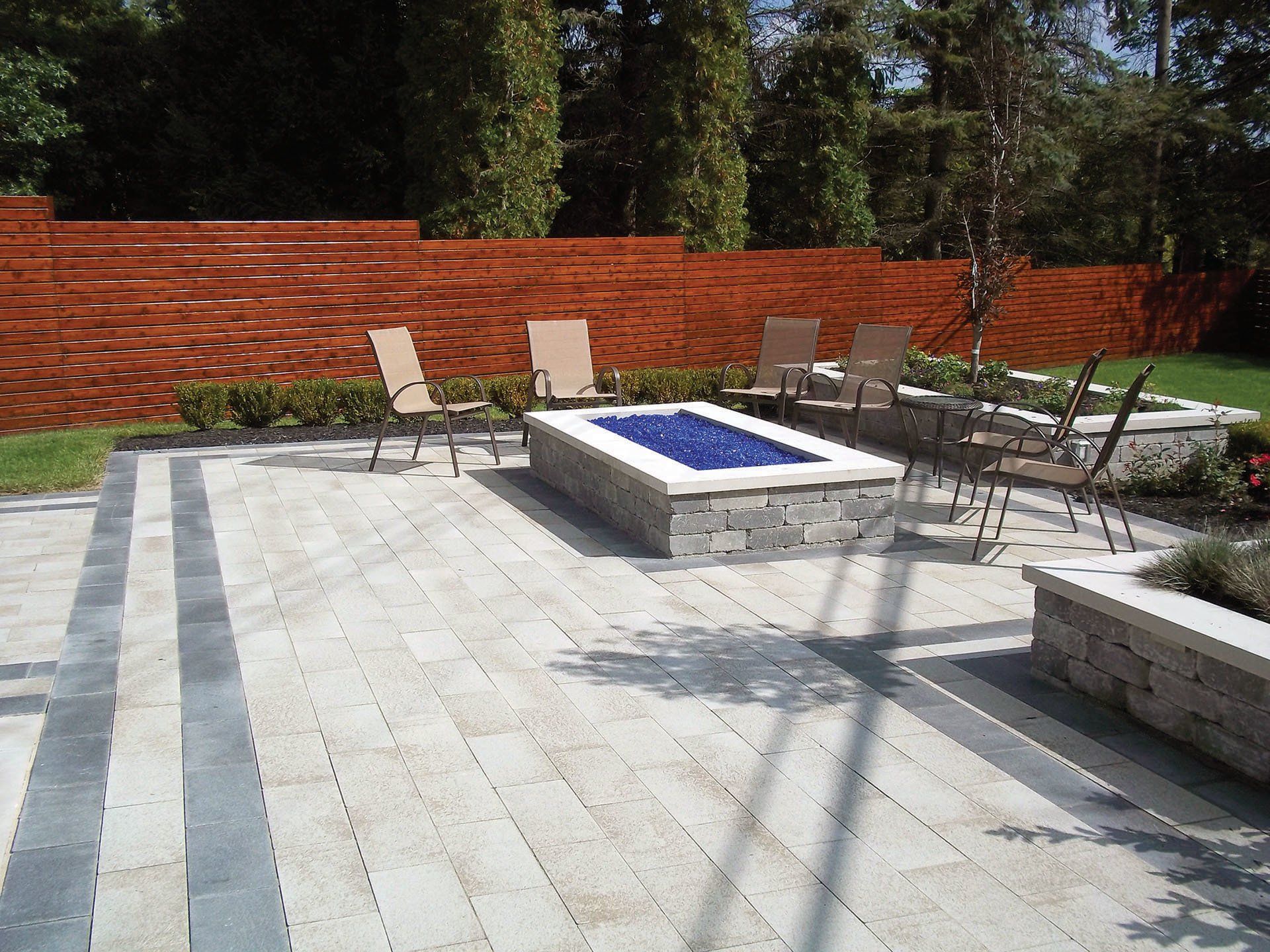a patio with chairs and a fire pit in the middle