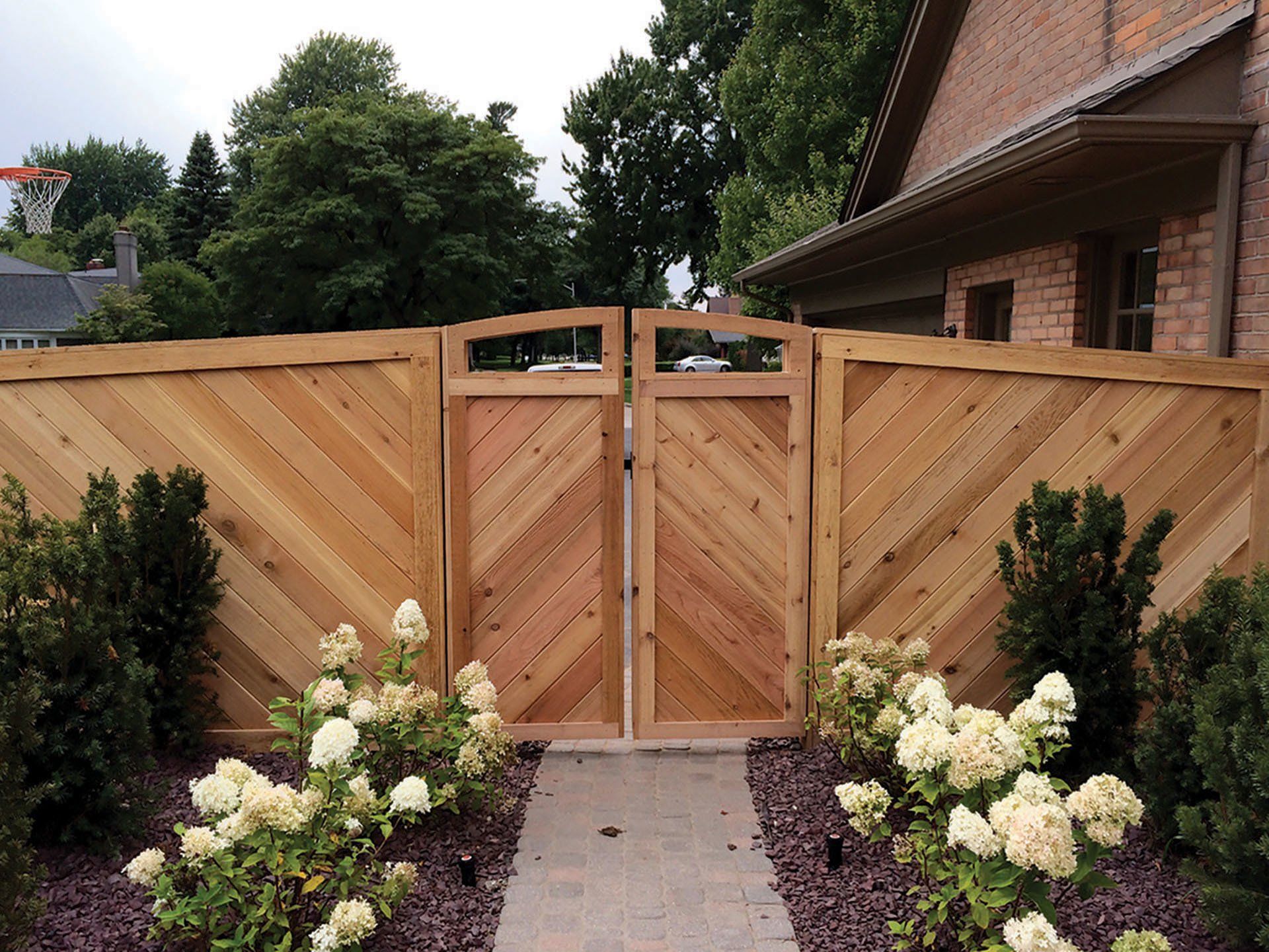 a wooden fence with a basketball hoop in the background