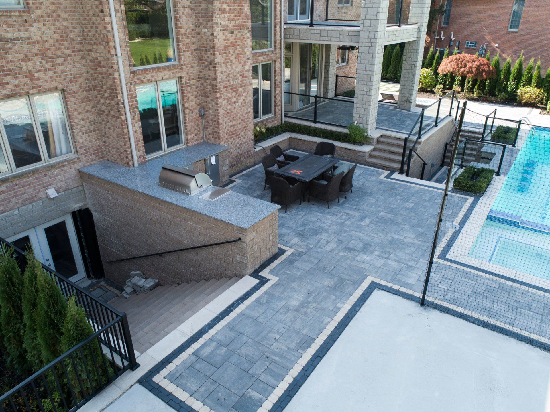 An aerial view of a patio with a table and chairs next to a pool.
