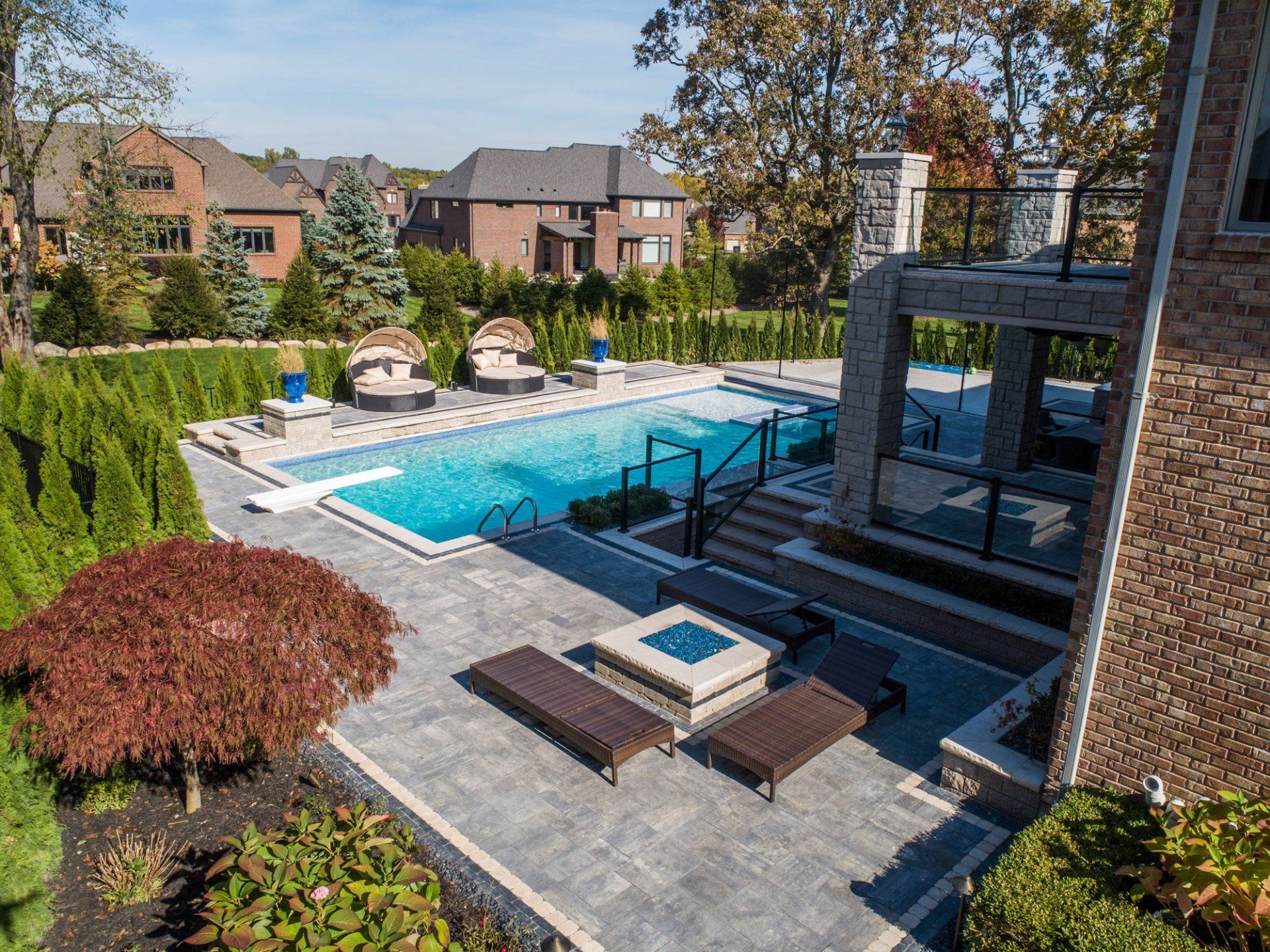 There is a large swimming pool in the backyard of a house.