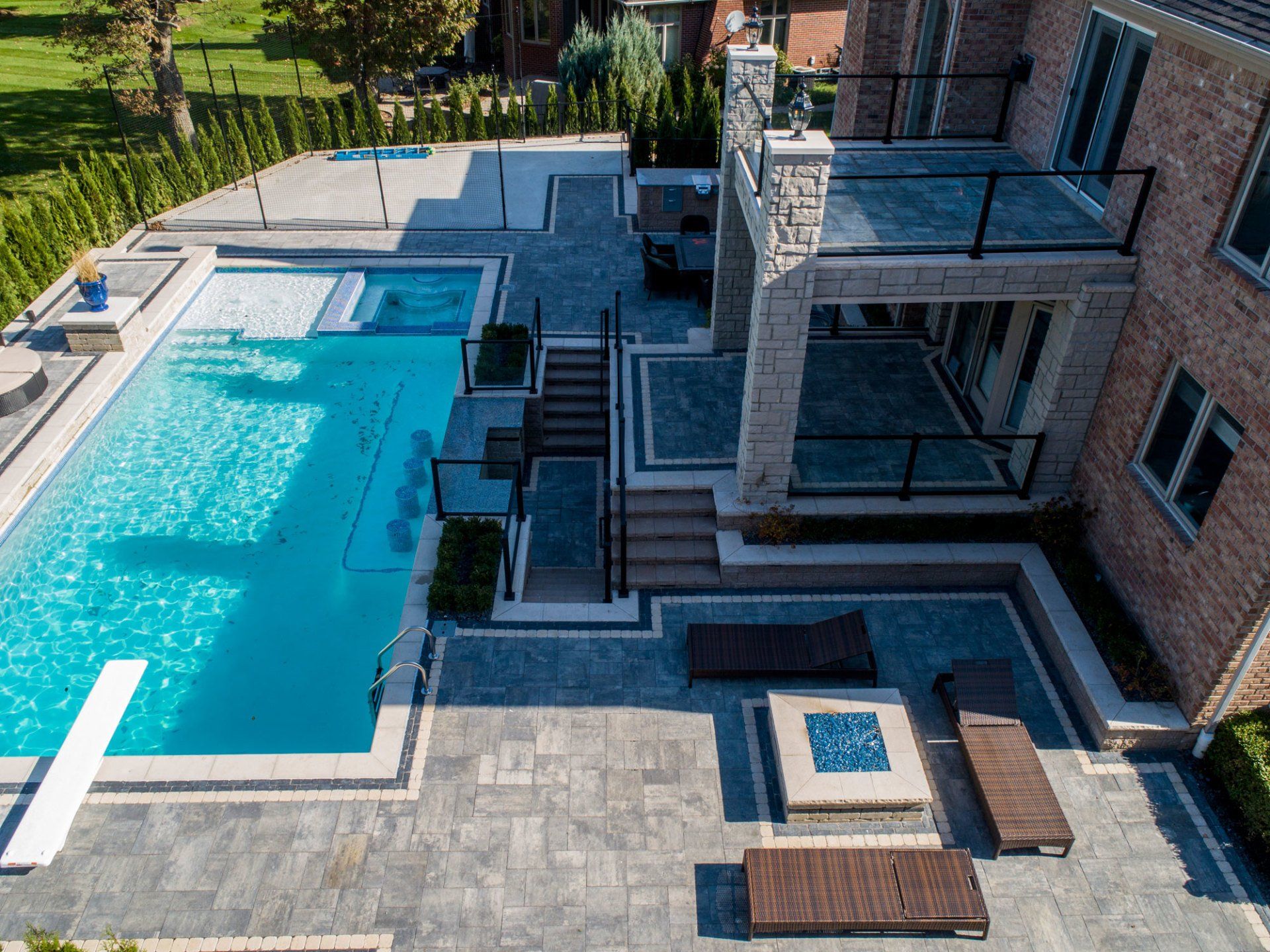 An aerial view of a large swimming pool in the backyard of a house.