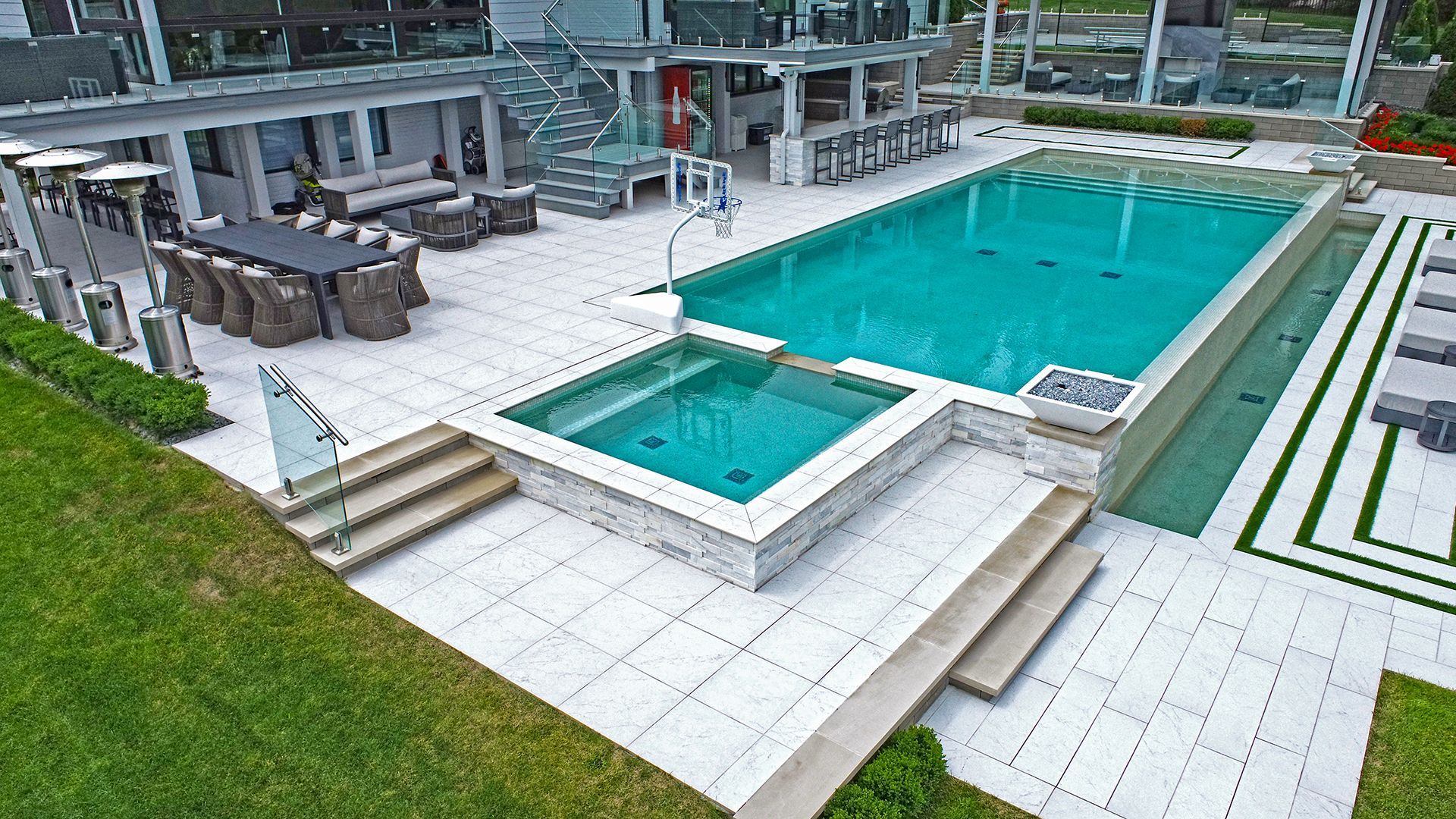 an aerial view of a large swimming pool and hot tub in a backyard .