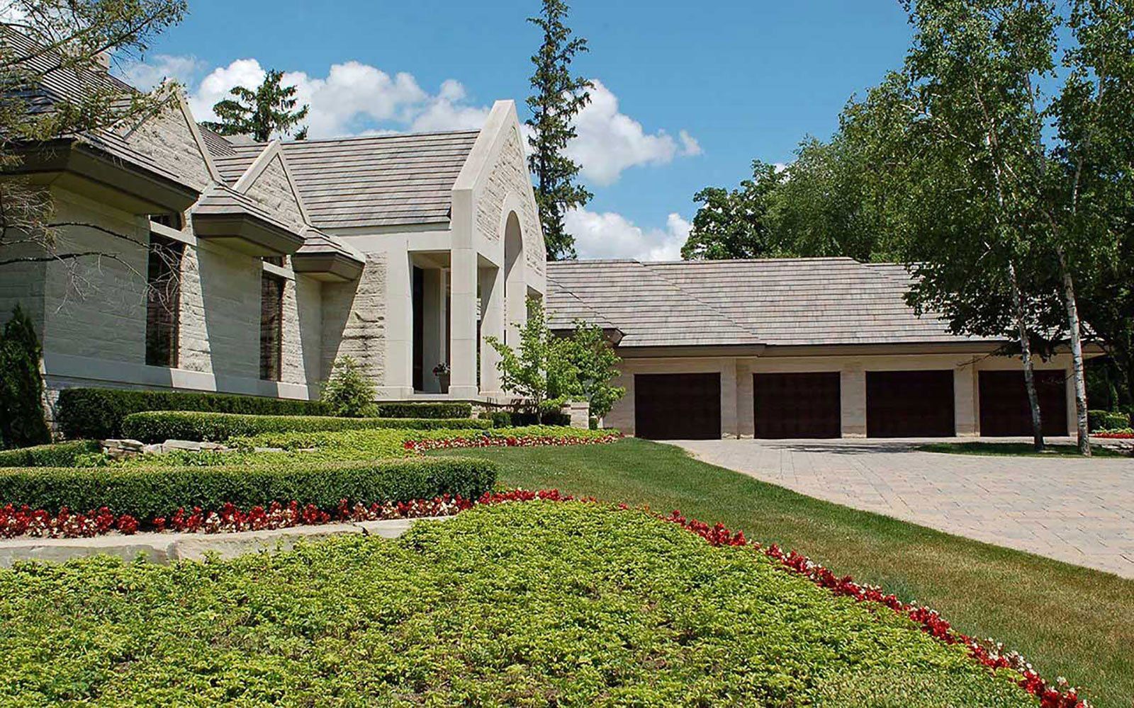 A large white house with three garage doors and a driveway