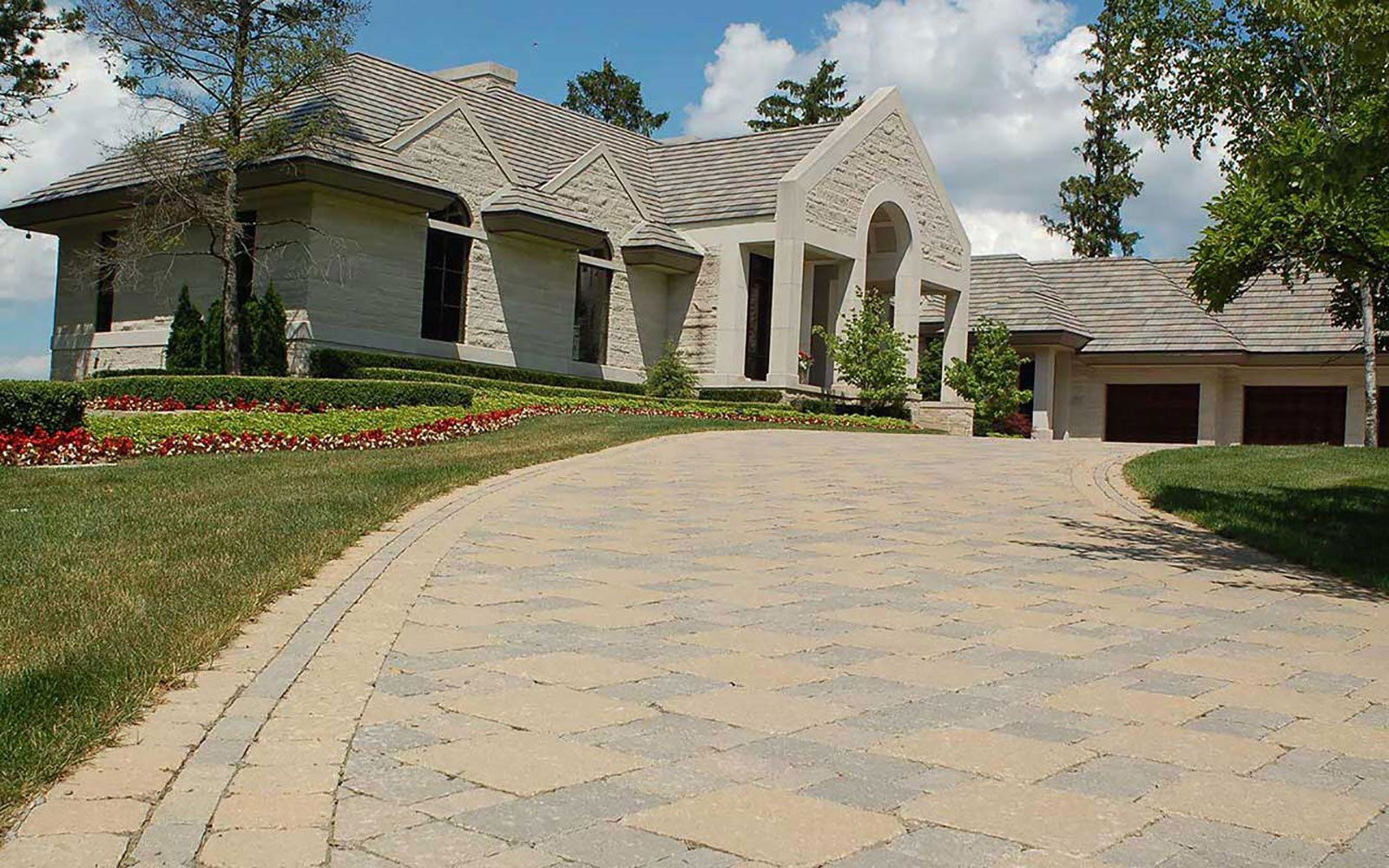 A large house with a brick driveway leading to it
