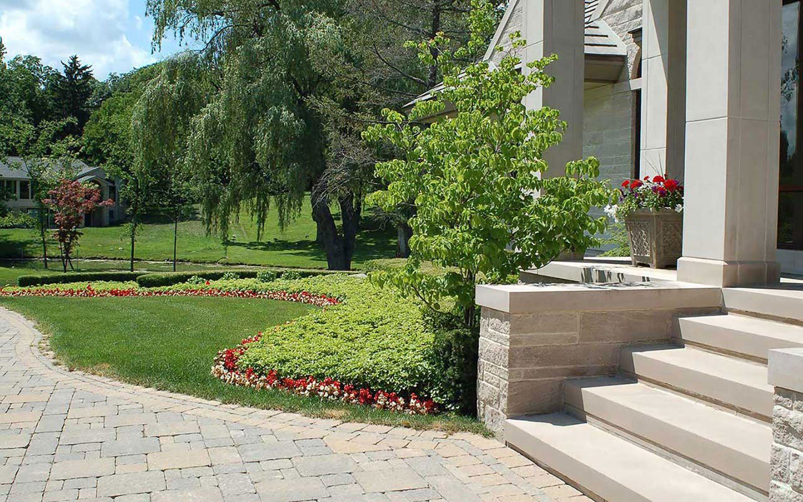 A house with a lush green lawn and stairs leading up to it