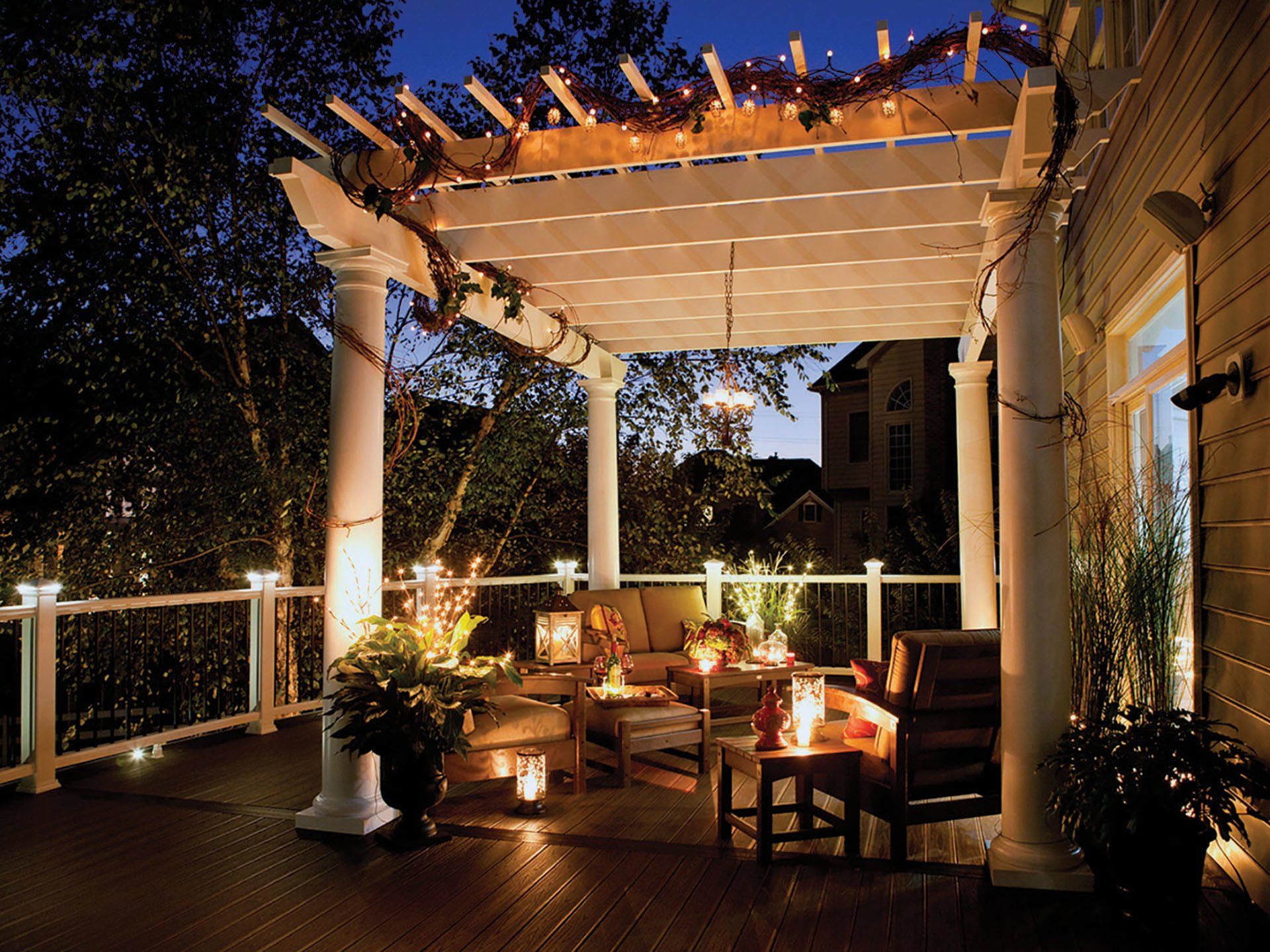a deck with a pergola and a couch underneath it