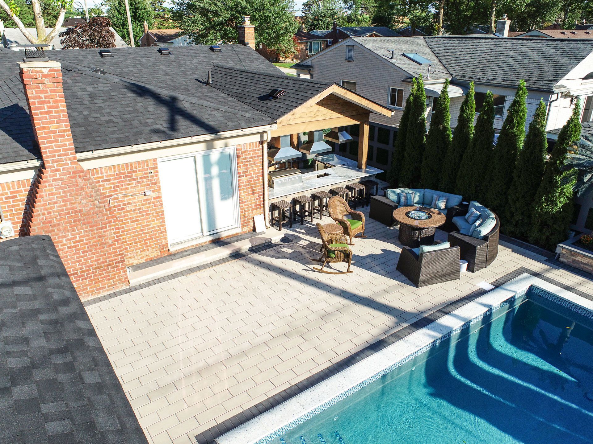 an aerial view of a backyard with a swimming pool and patio furniture .