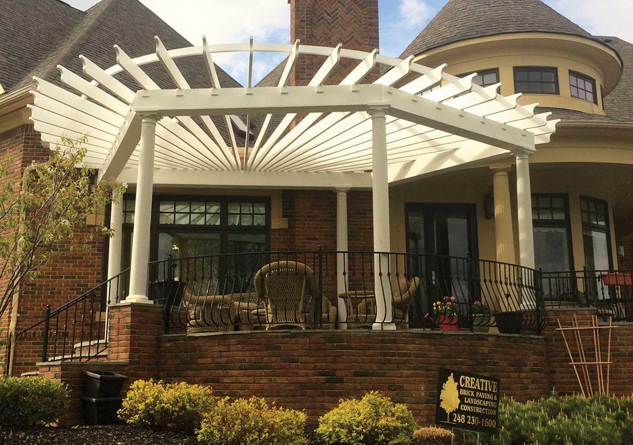 a large house with a white pergola on the back porch .