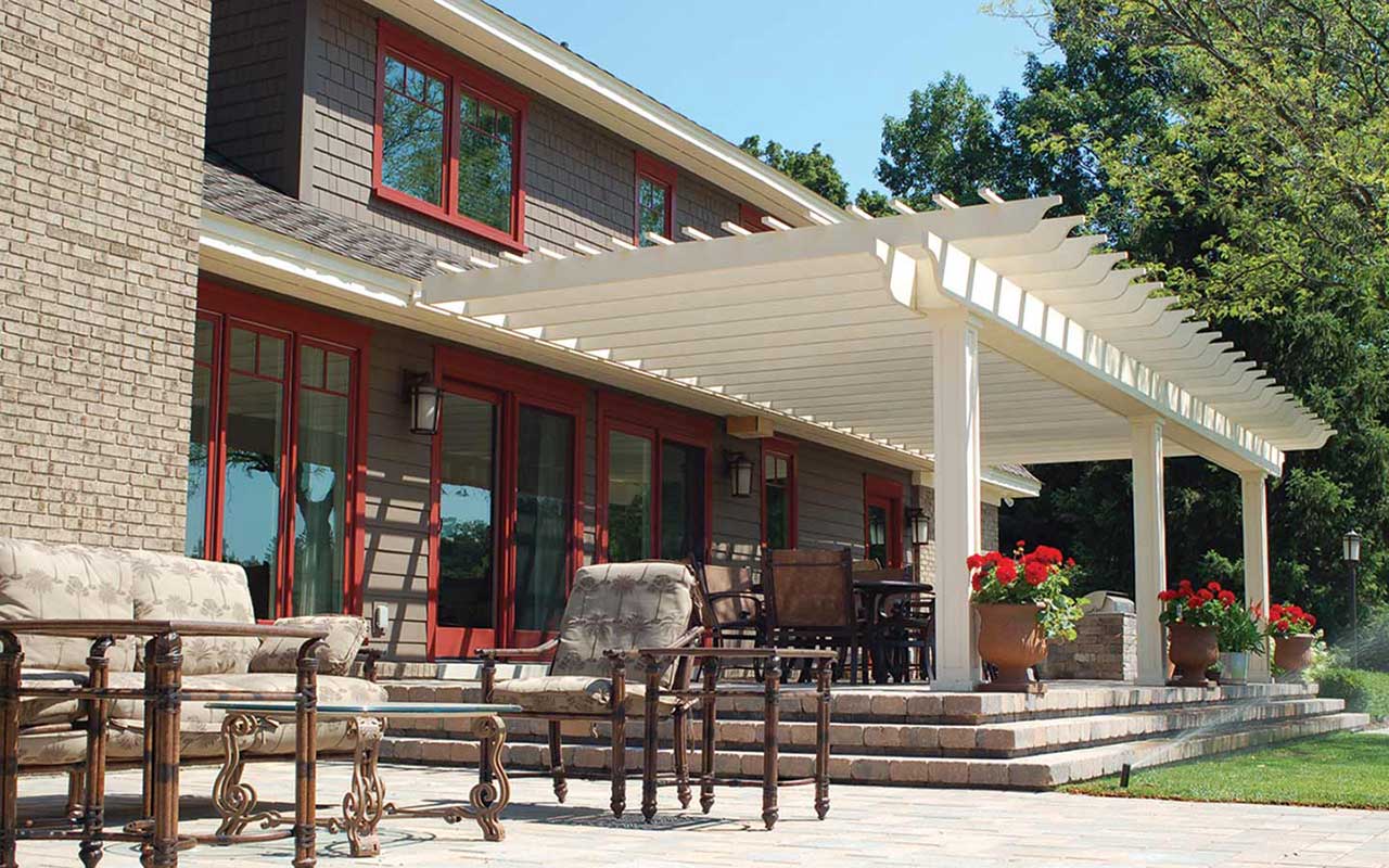 a large house with a pergola and patio furniture